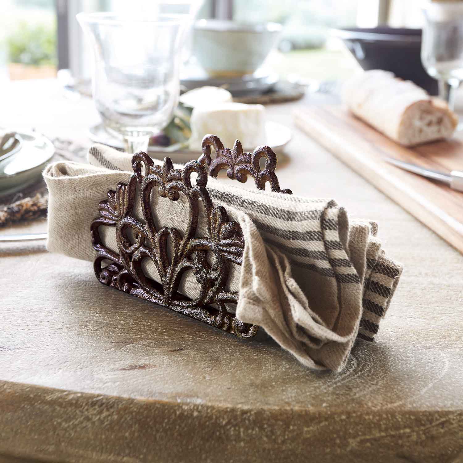 Porte-serviettes en métal rustique avec motif décoratif et serviette en lin sur table