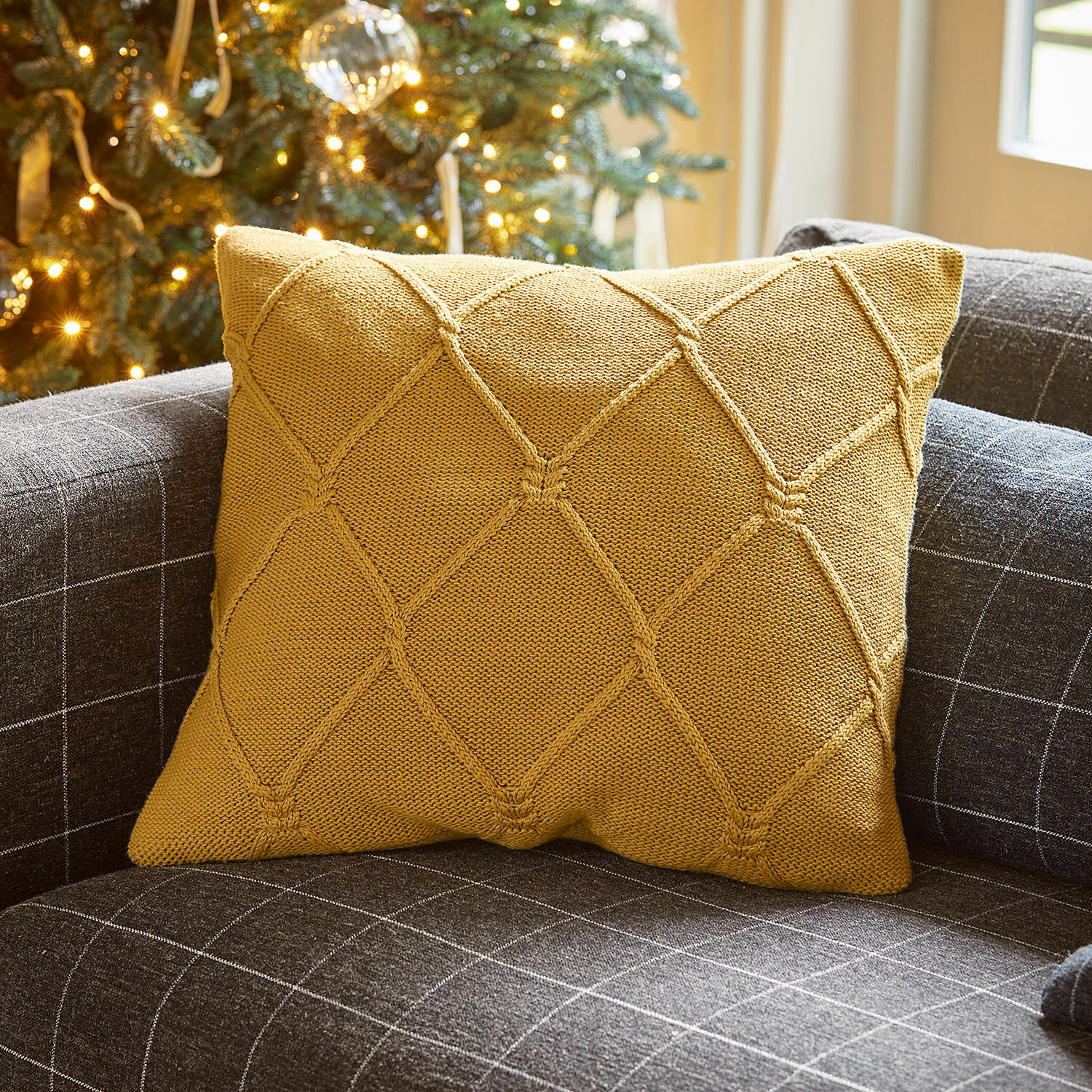 Housse de coussin Cresil Coussin décoratif moutarde en tricot sur canapé gris à motif carreaux pour salon cosy
