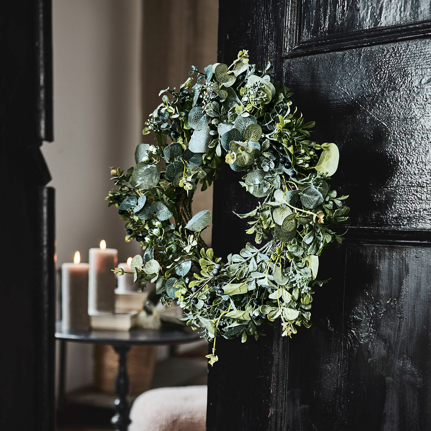Couronne Tobin Couronne décorative en feuillage vert et baies sur porte noire, décoration intérieure