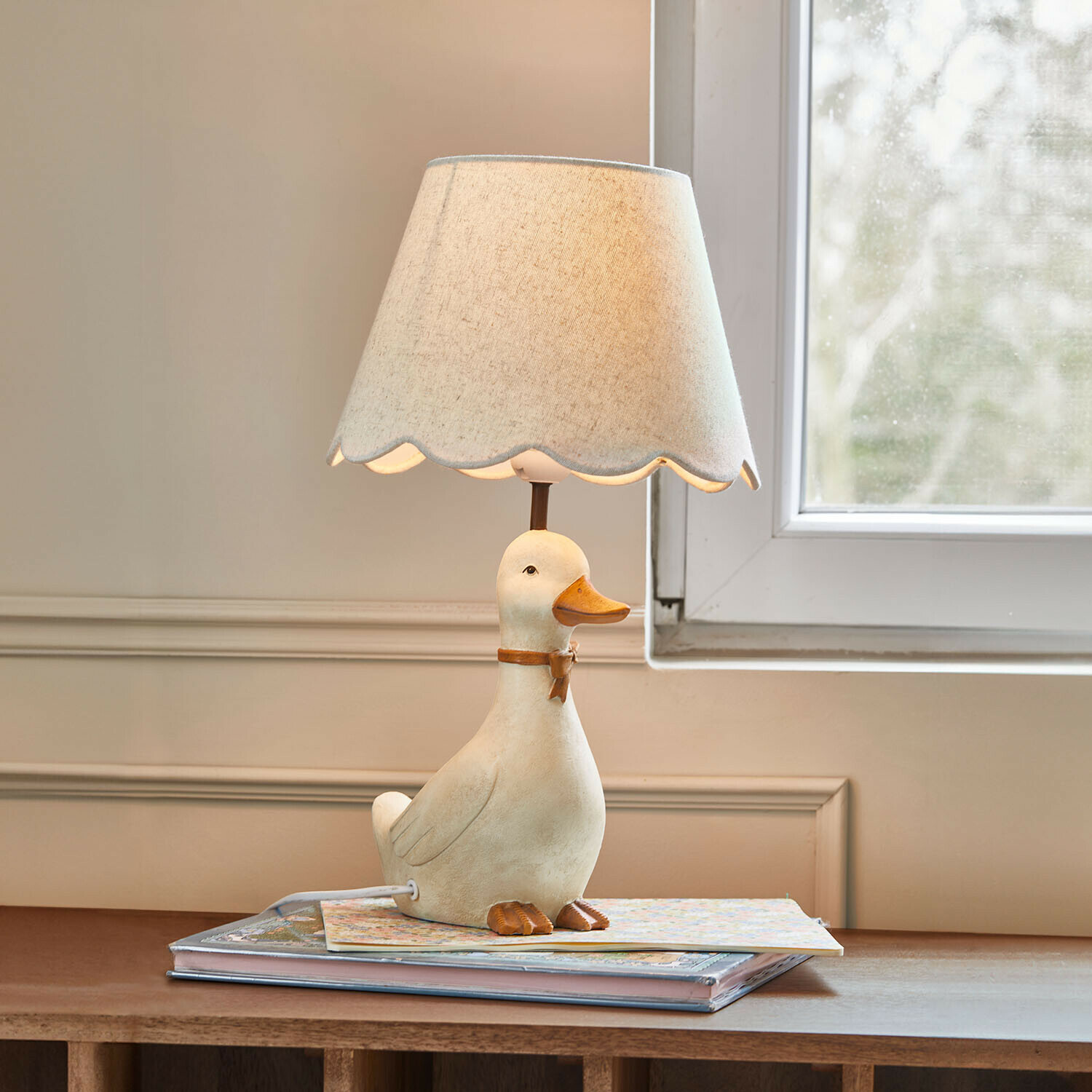Lampe de table avec base en forme de canard blanc et abat-jour beige à bord ondulé