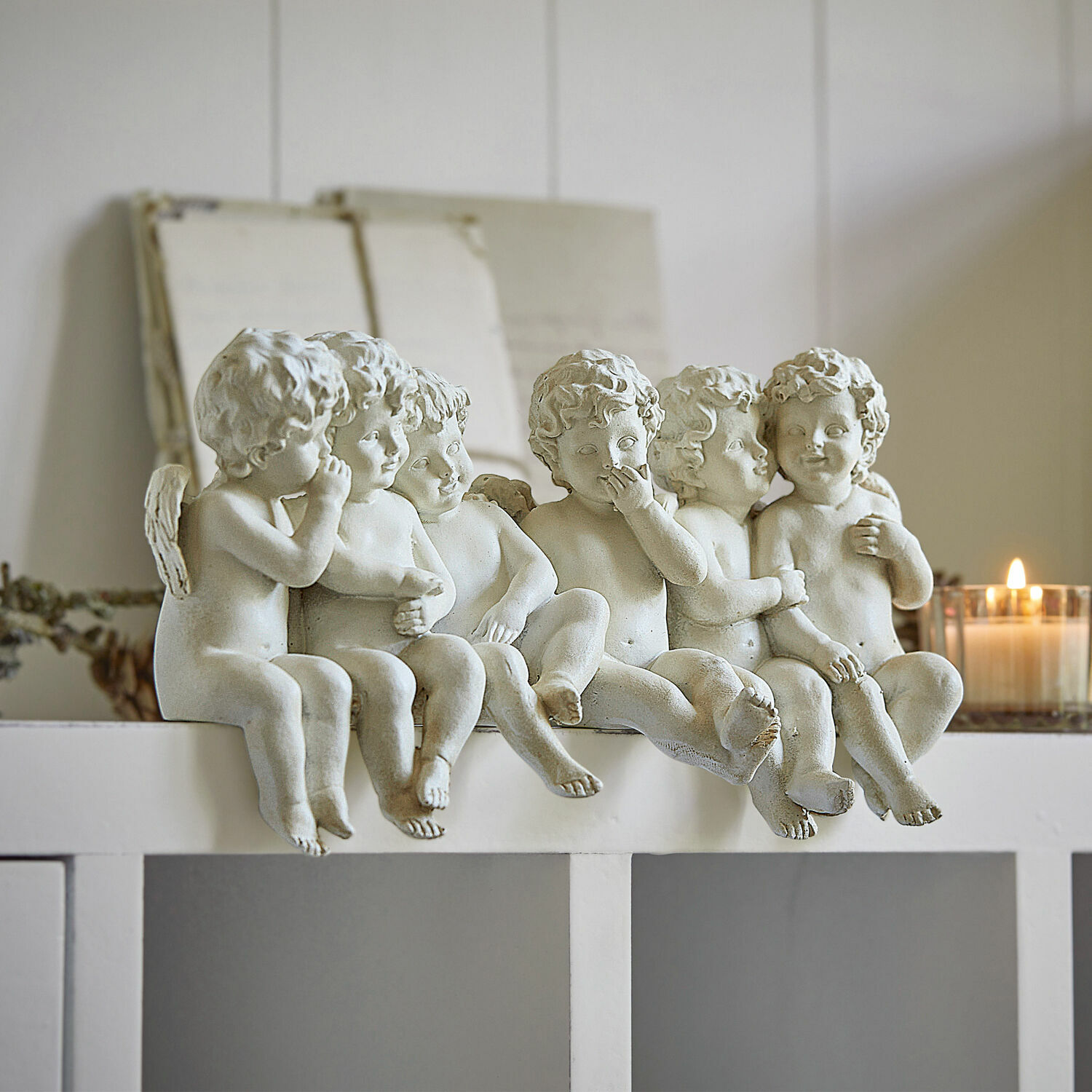 Anges Léon Sculptures de six petits anges blancs en résine posés sur une étagère blanche, décoration intérieure