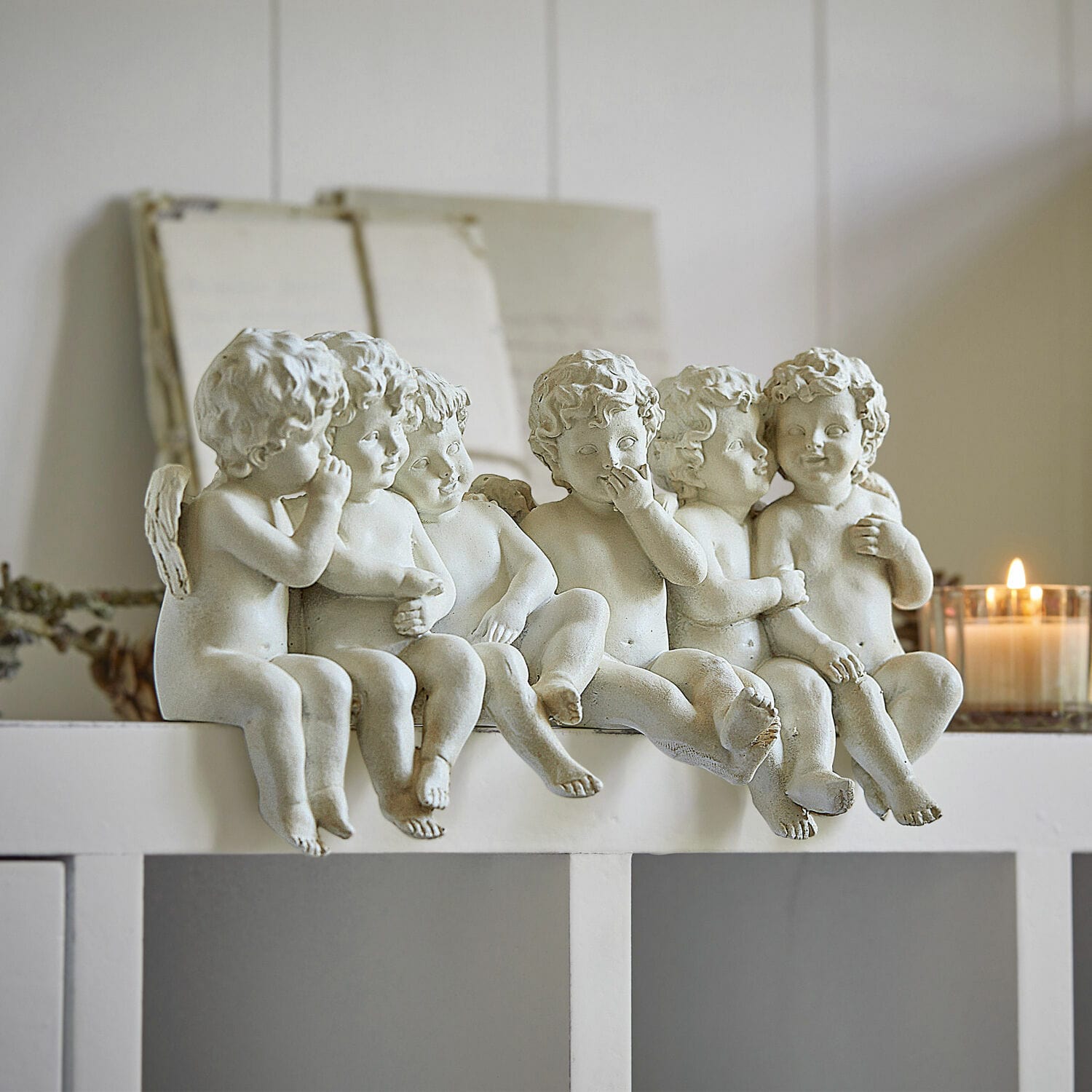 Anges Léon Sculptures de six petits anges blancs en résine posés sur une étagère blanche, décoration intérieure