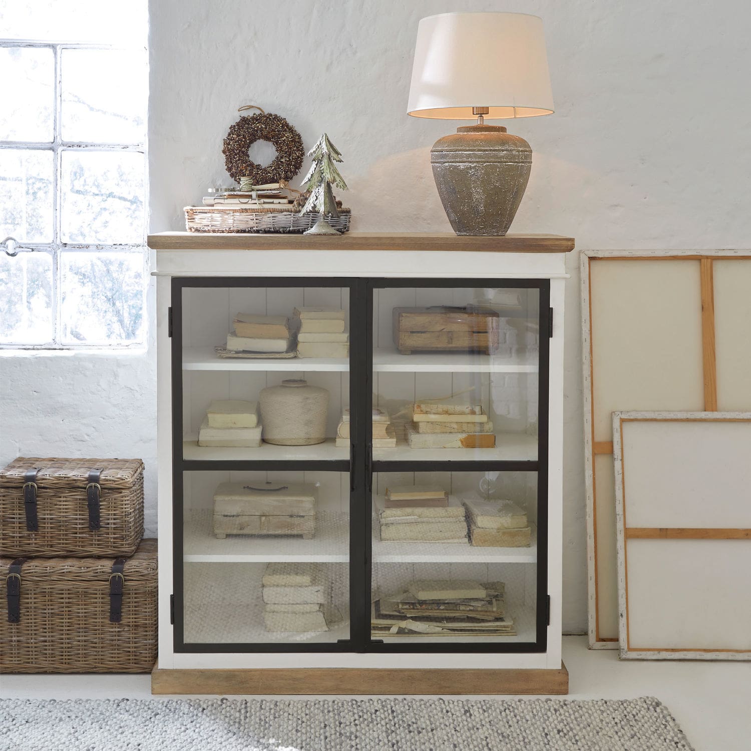 Commode Mira Buffet en bois blanc avec portes vitrées et lampe en céramique sur le dessus dans un style vintage