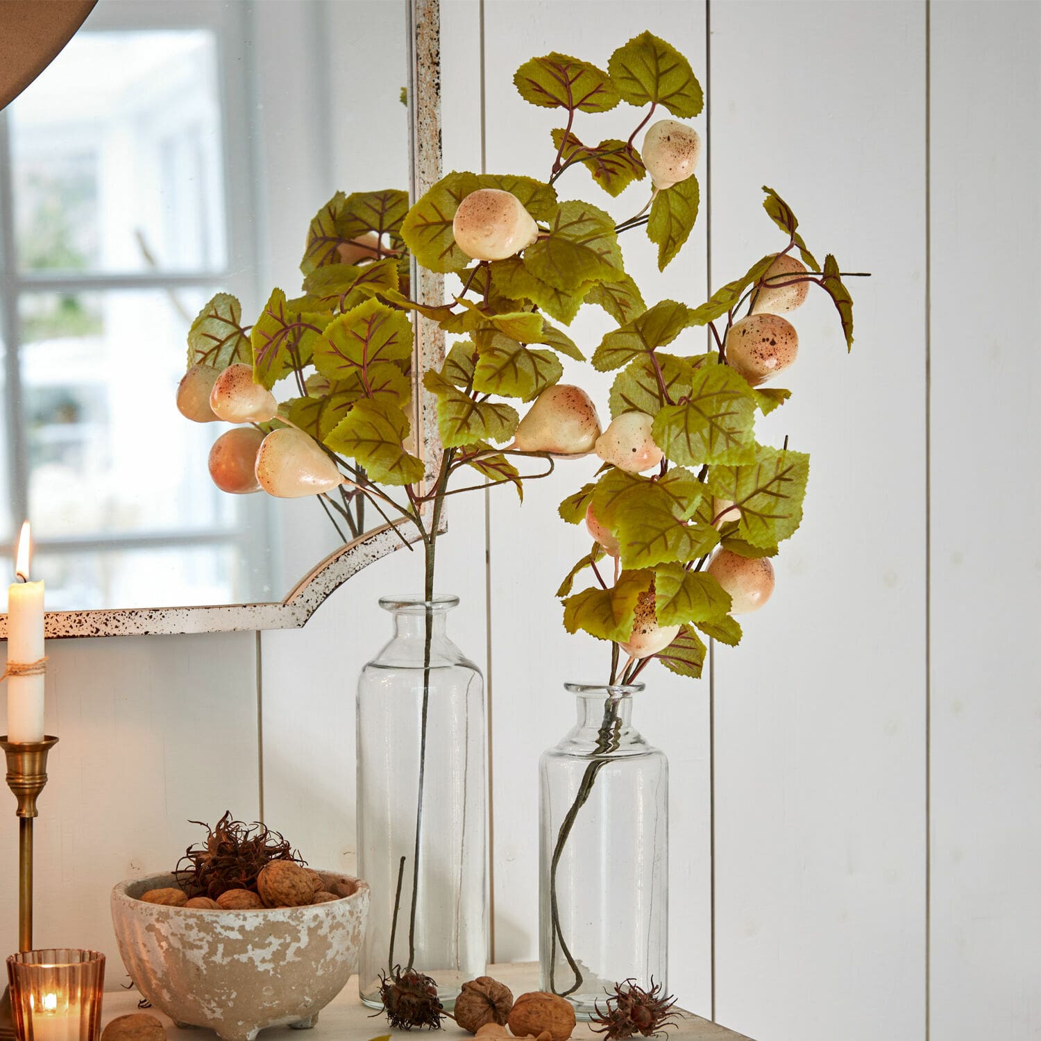 Lot de 2 tiges décoratives Aidan Branches décoratives avec feuilles vertes et fruits crème dans des vases en verre transparent sur fond blanc