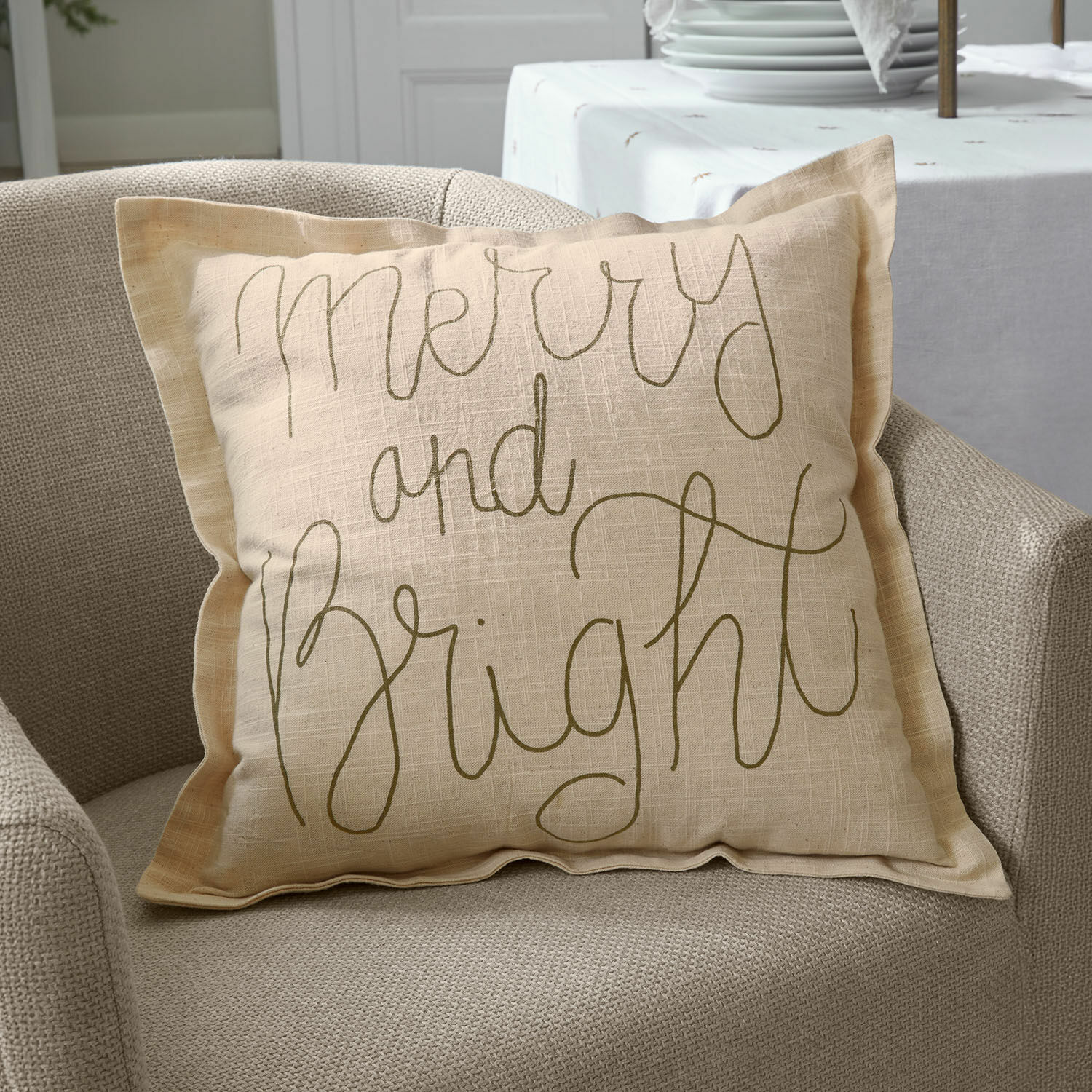 Housse de coussin Torvenna Coussin décoratif beige en lin avec inscription Merry and Bright sur fauteuil beige, décoration intérieure