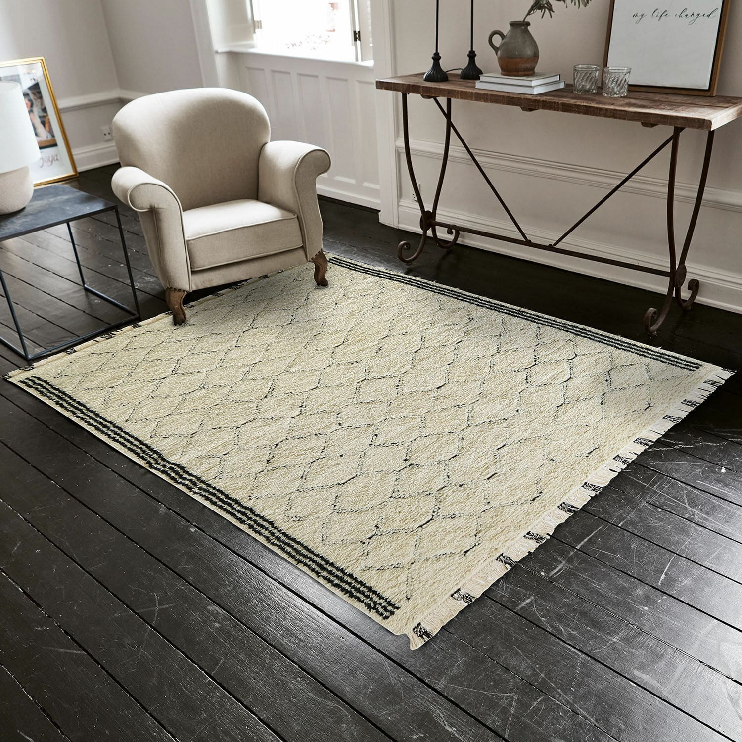 Tapis Himesto Tapis beige à motif géométrique avec franges sur un sol en bois foncé dans un salon moderne