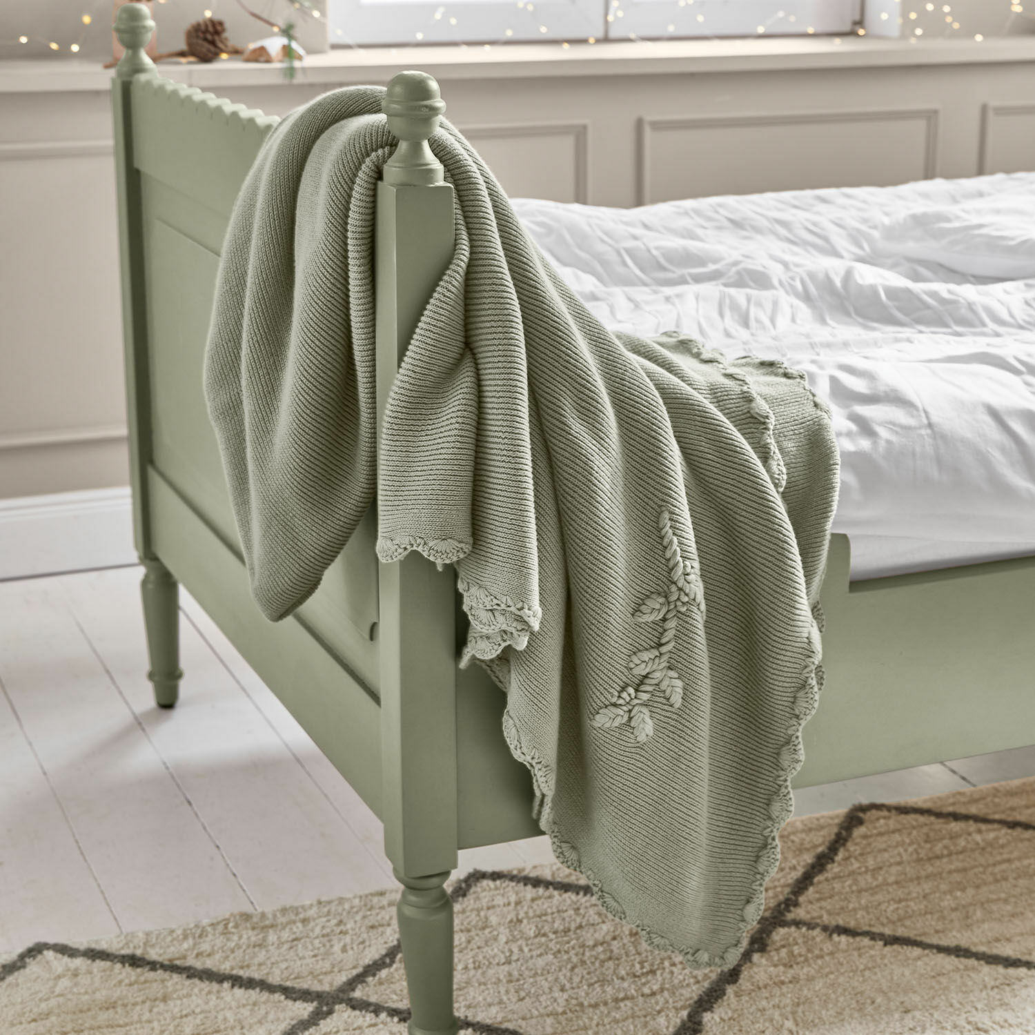 Plaid Aisven Plaid vert menthe en coton avec broderie sur lit en bois dans une chambre lumineuse, décoration intérieure