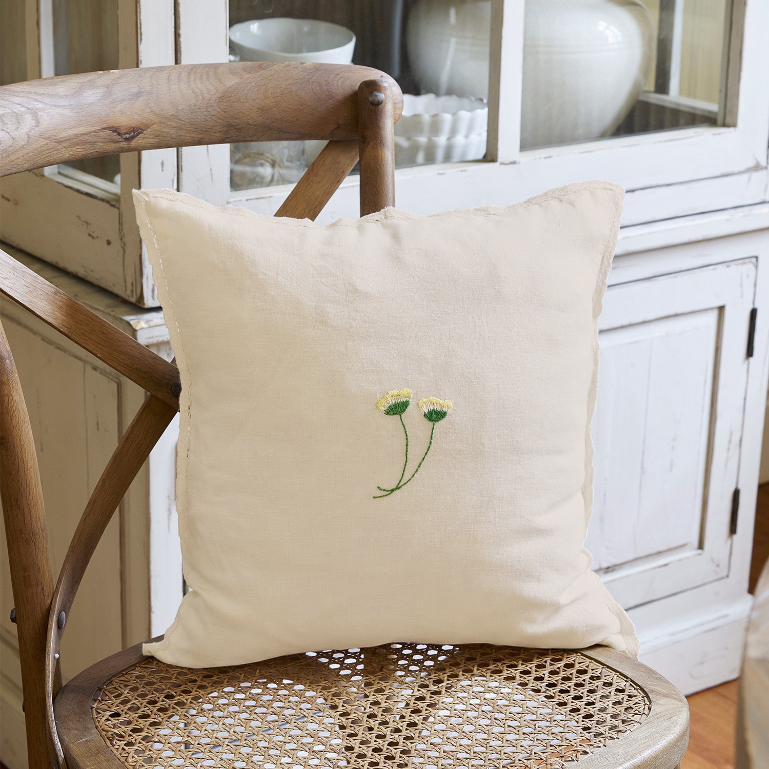 Housse de coussin Dijon Coussin beige en lin avec broderie de fleurs jaunes sur chaise en osier pour décoration intérieure