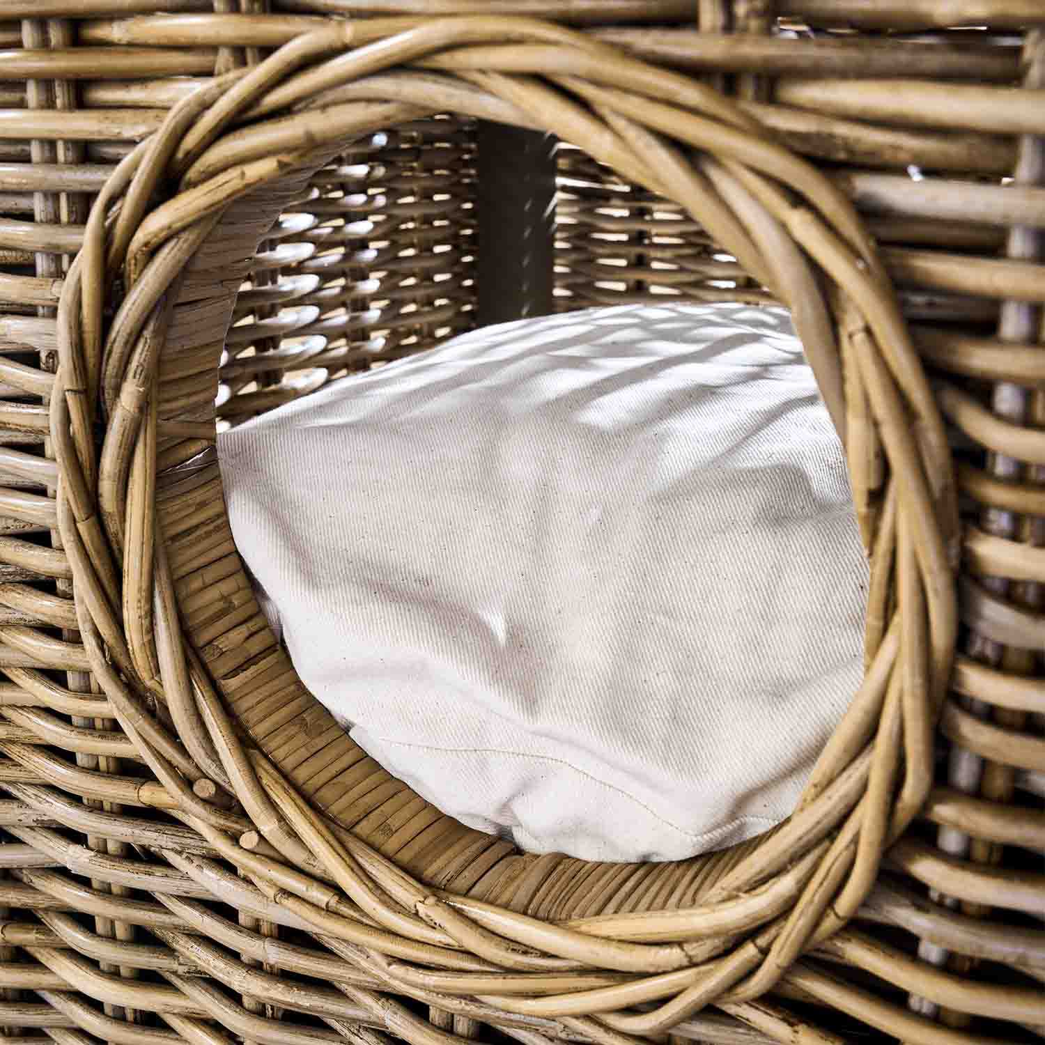 Entrée ronde d'un panier en osier avec coussin blanc, matériau naturel et couleur beige