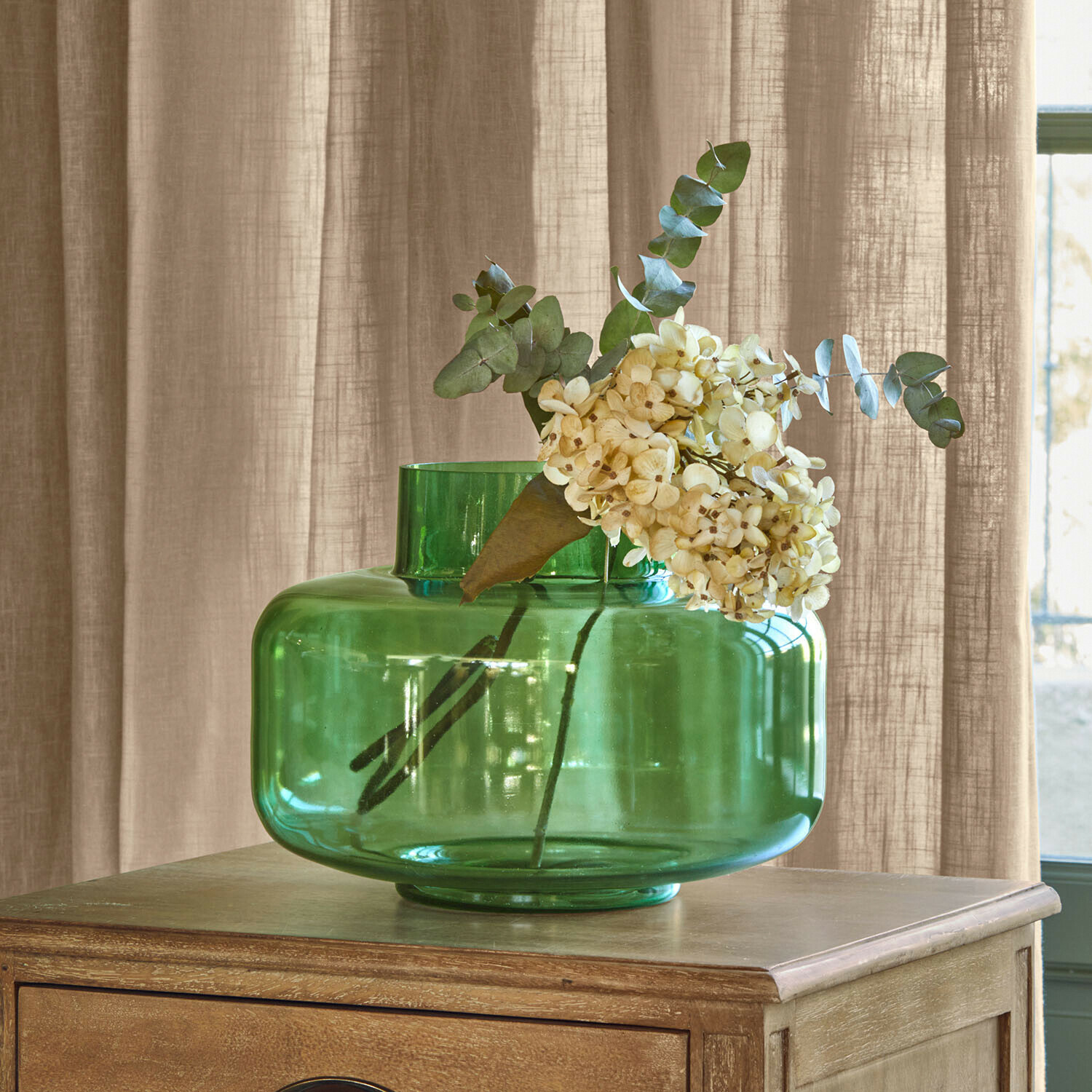 Vase Ésmarine Vase en verre vert avec fleurs crème sur table en bois, décoration intérieure élégante