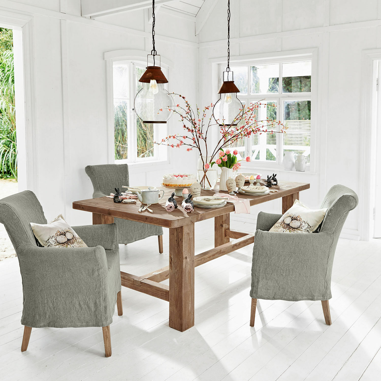 Table Oteley Salle à manger avec table en bois et chaises rembourrées grises dans un intérieur lumineux et moderne