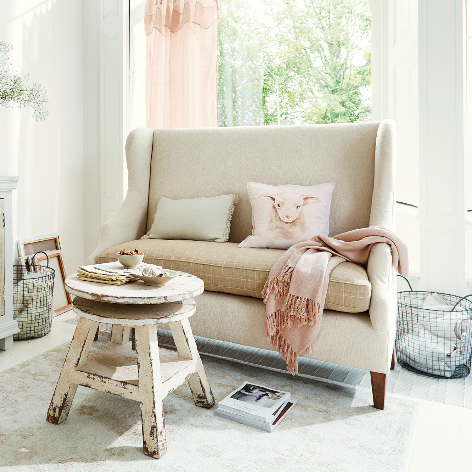Canapé Ombra Canapé beige en tissu avec coussin motif agneau et table basse en bois rustique dans un salon lumineux