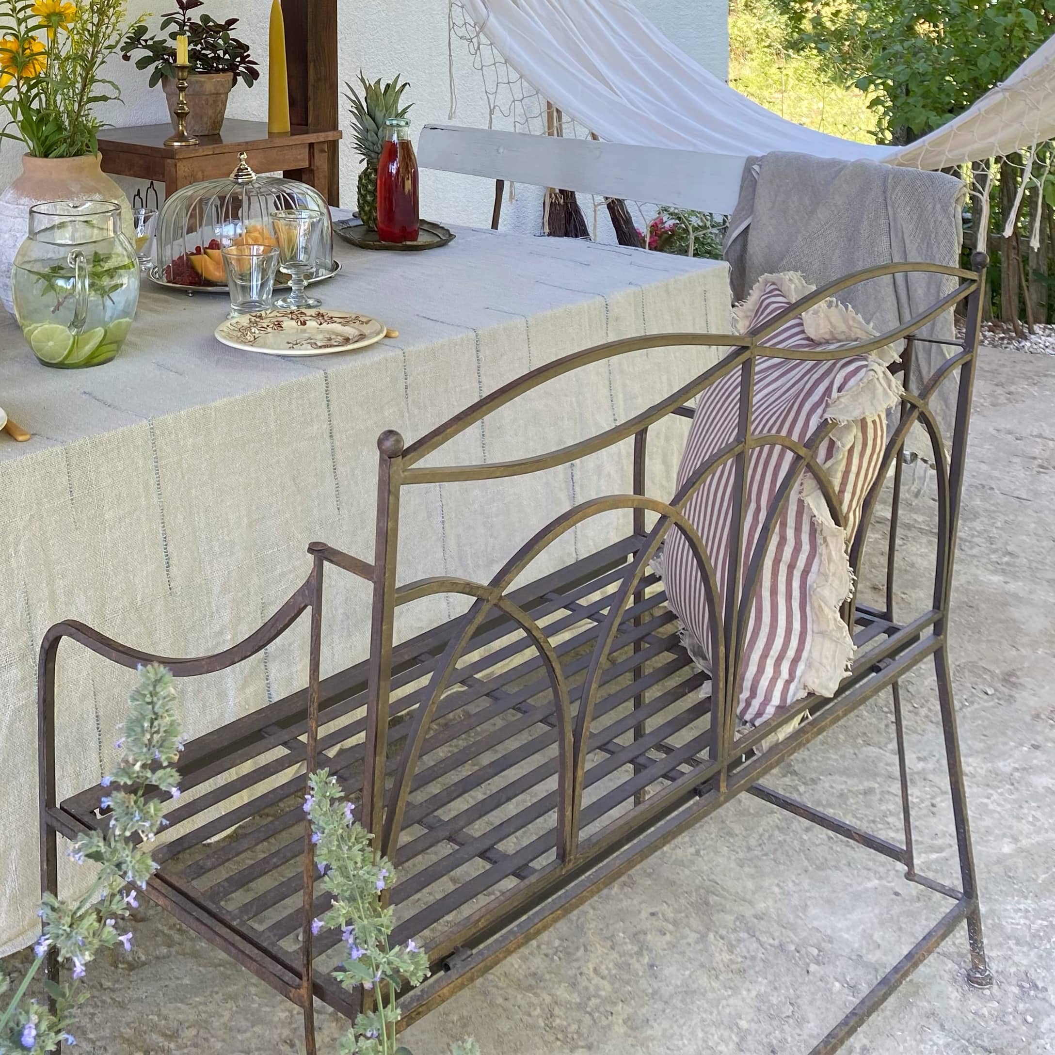 Banc de jardin en métal style vintage avec coussin rayé, parfait pour la détente en terrasse