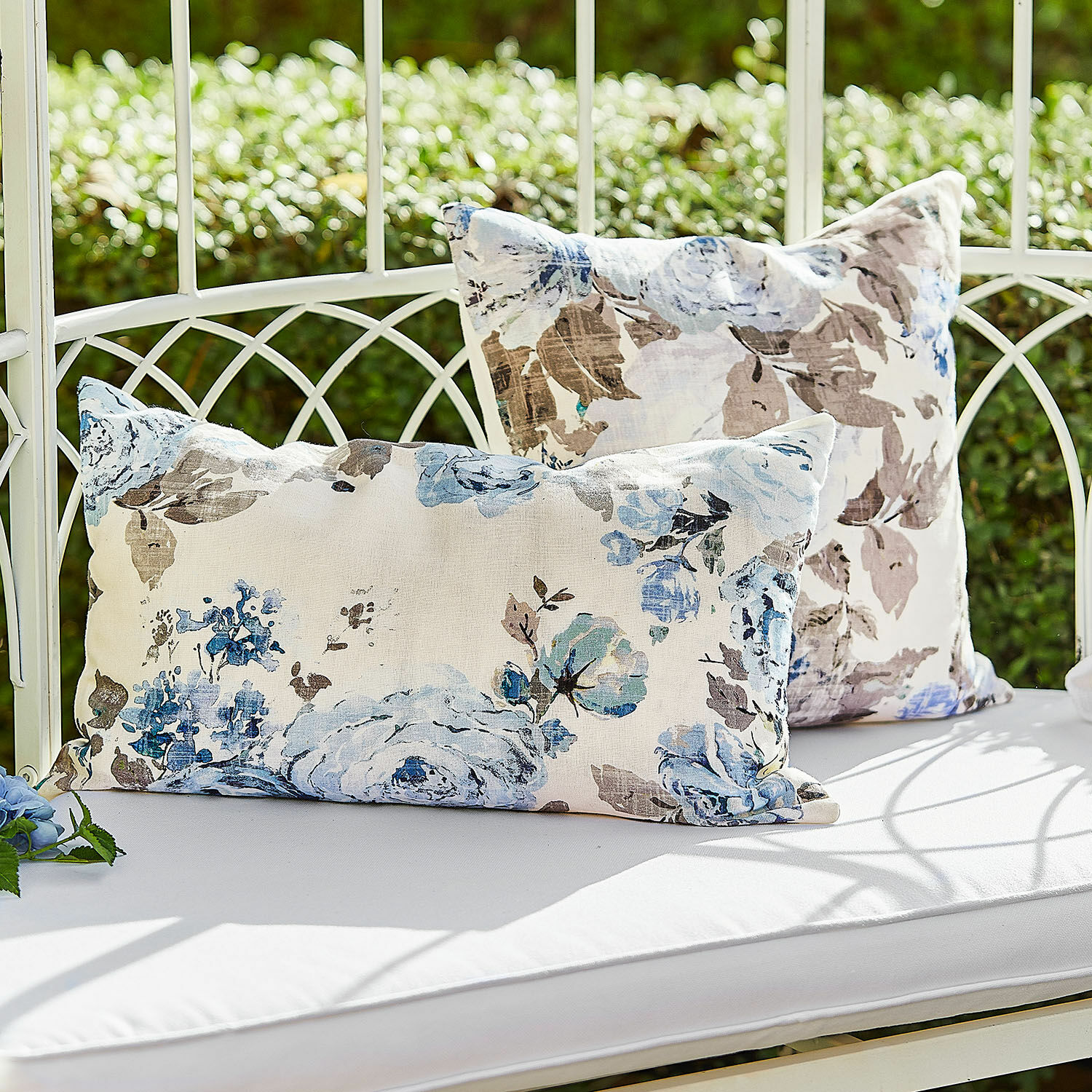 Lot de 2 housses de coussins Cloranne Coussins décoratifs en coton à motif floral bleu et marron sur un banc blanc en extérieur