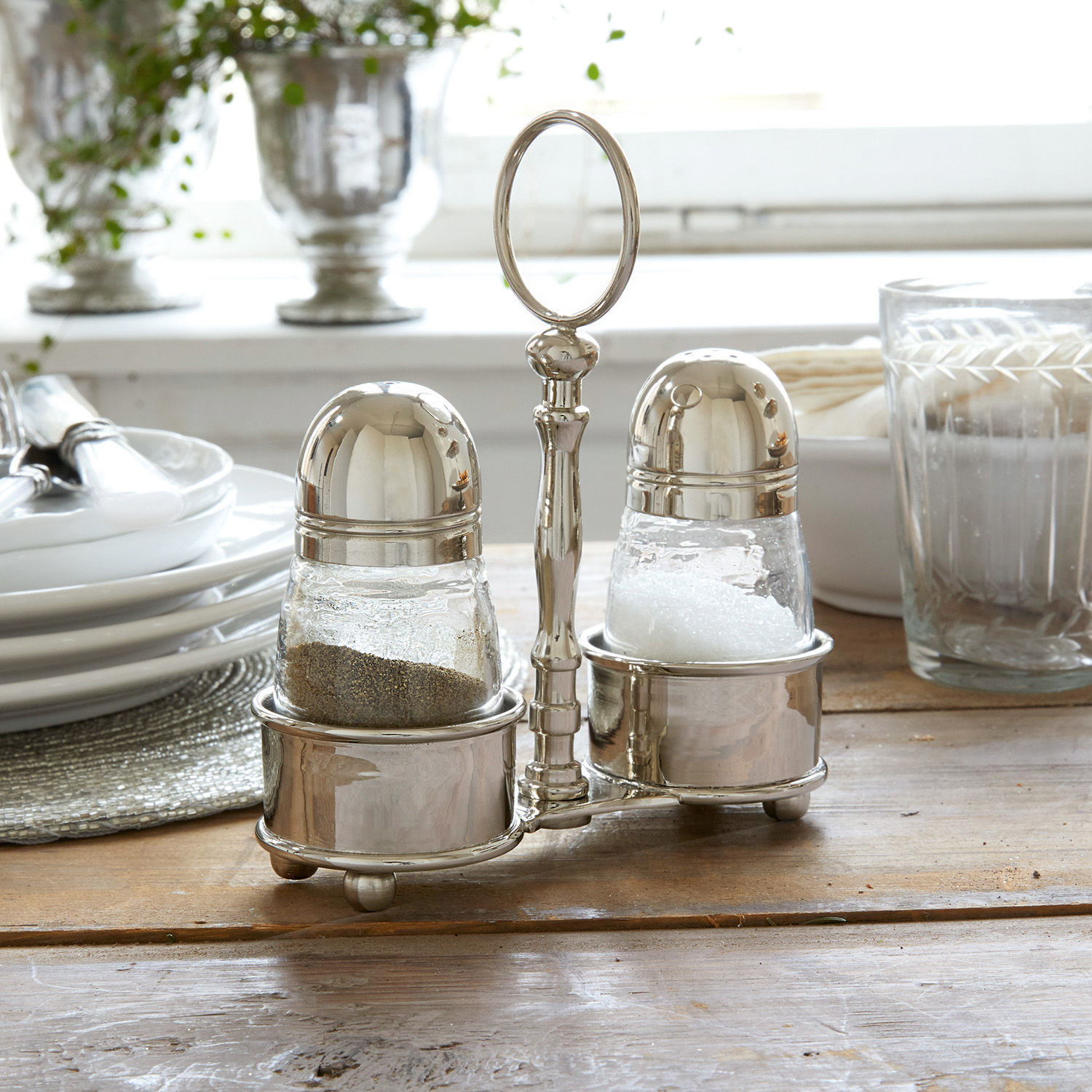 Ménagère sel et poivre Beaune Ensemble salière et poivrière en verre et métal argenté sur table en bois dans une salle à manger