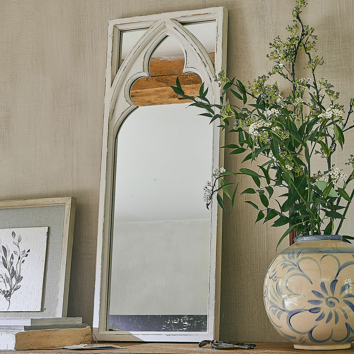 Miroir Golvine Miroir en bois blanc avec motif gothique sur une table en bois avec vase fleuri décoratif