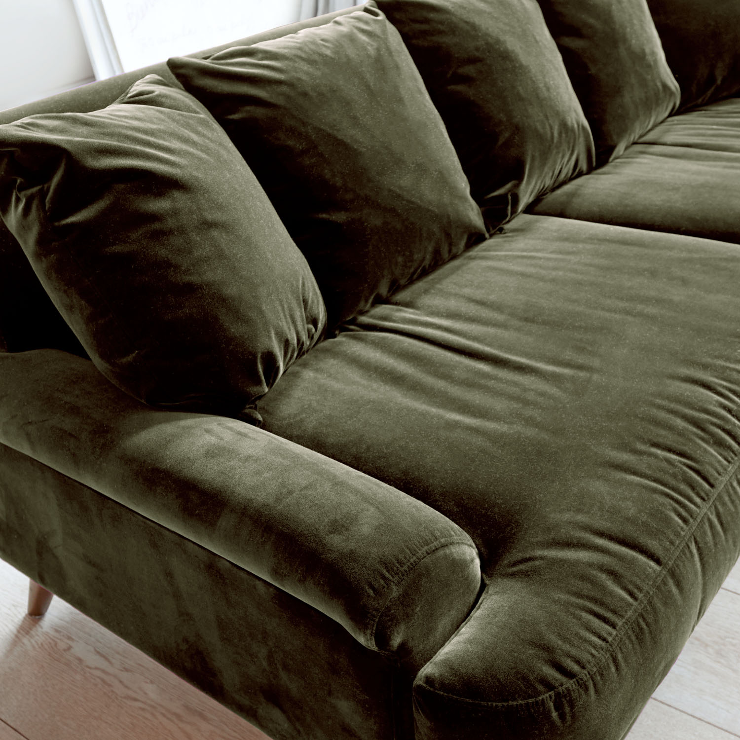 Canapé vert en velours avec coussins moelleux et accoudoirs confortables pour salon