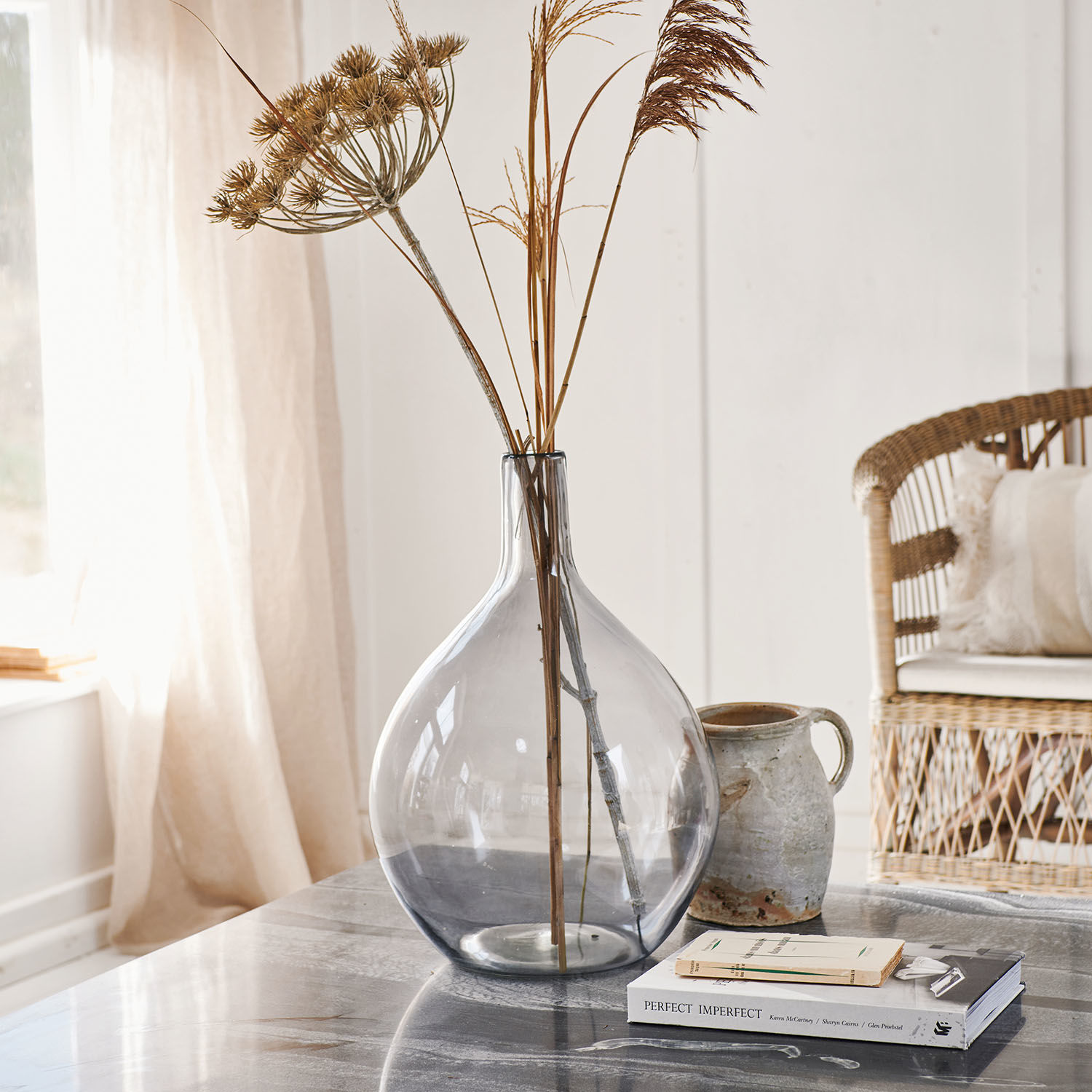 Vase Argonne Vase en verre transparent avec herbes sèches sur une table en marbre dans un intérieur lumineux