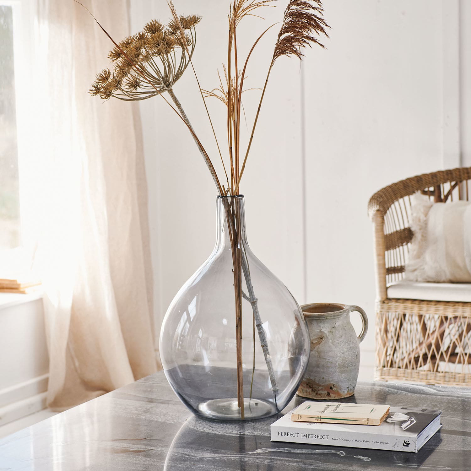 Vase Argonne Vase en verre transparent avec herbes sèches sur une table en marbre dans un intérieur lumineux