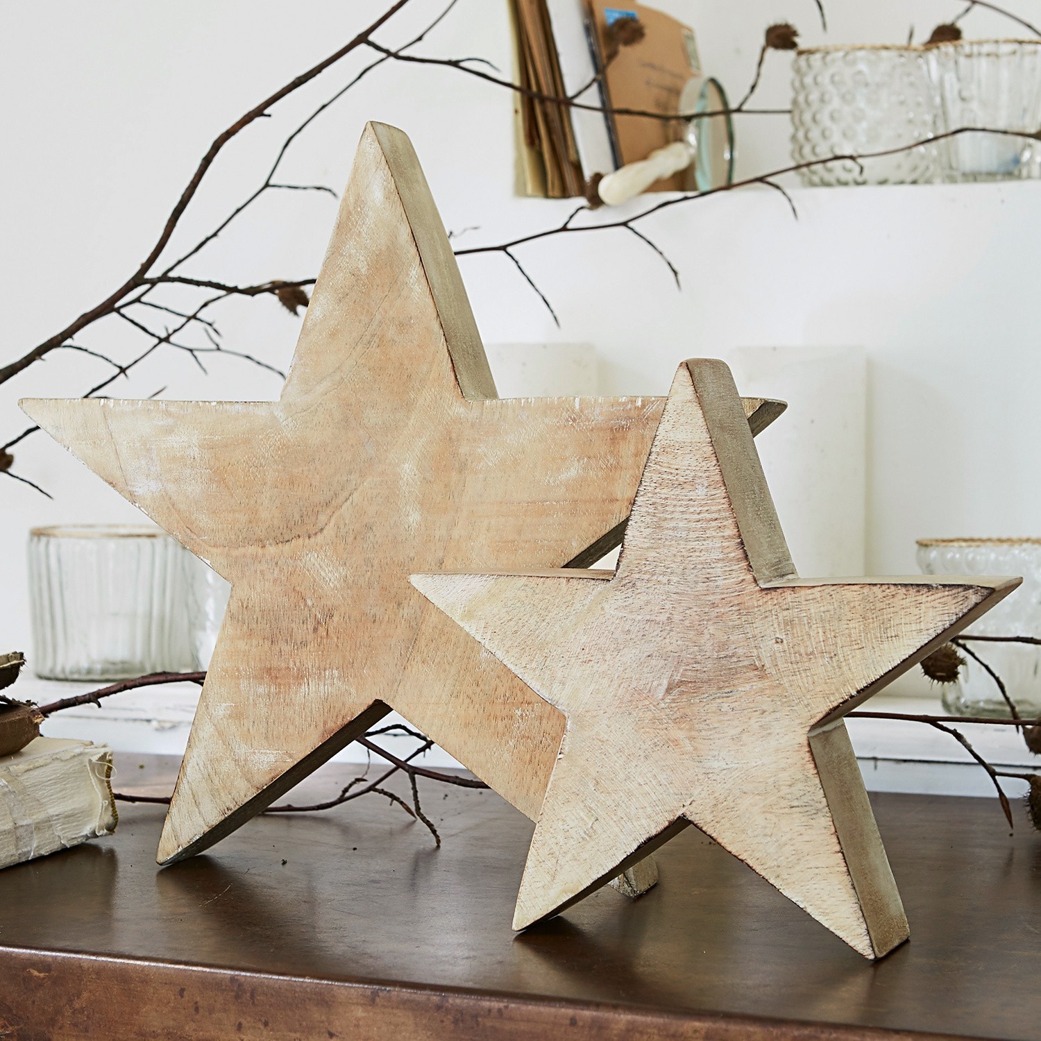 Lot de 2 étoiles Dunino Étoiles décoratives en bois couleur naturelle posées sur une table, décoration intérieure rustique