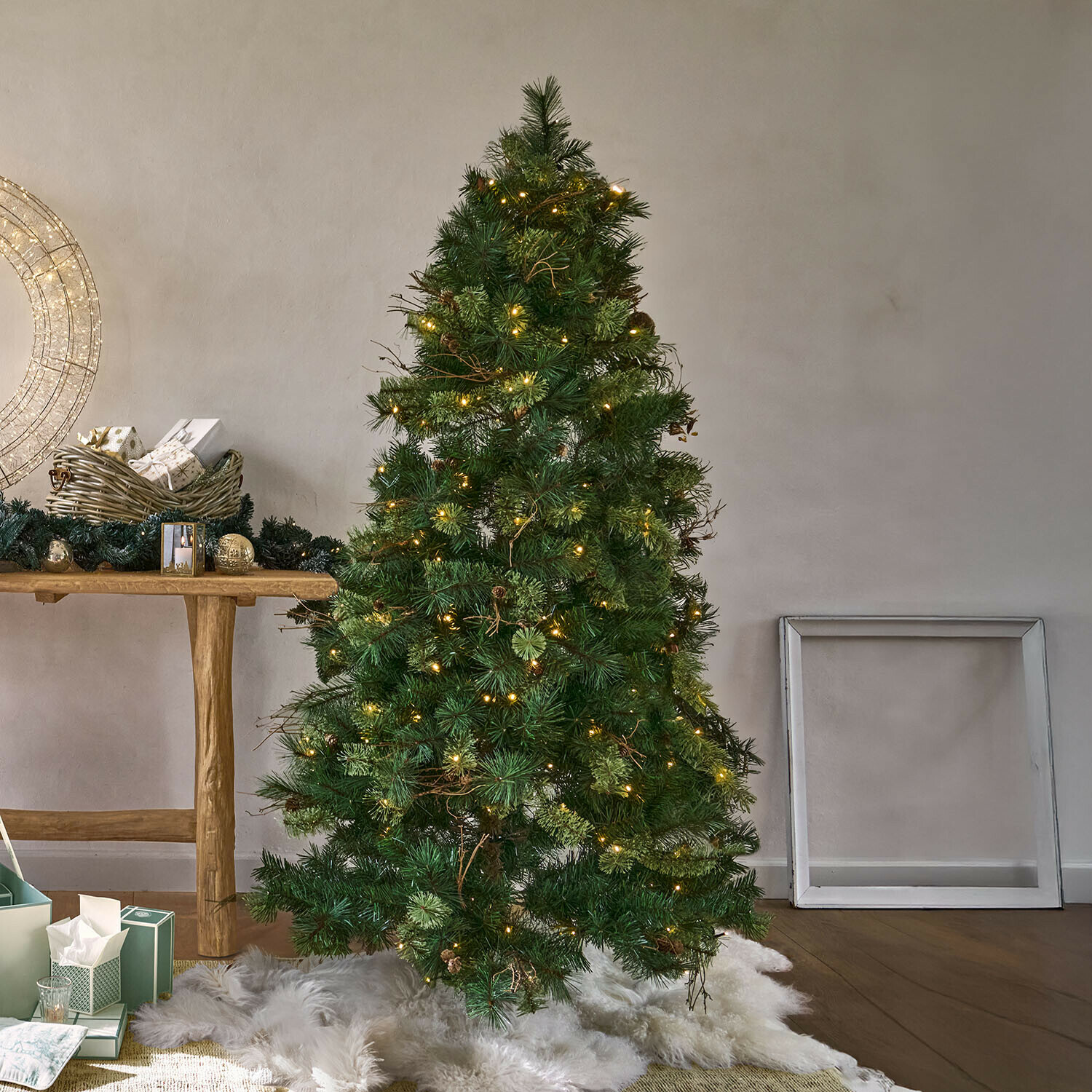 Sapin de Noël LED Yundra Sapin artificiel vert avec aiguilles et guirlande lumineuse LED chaude sur tapis en fausse fourrure blanche