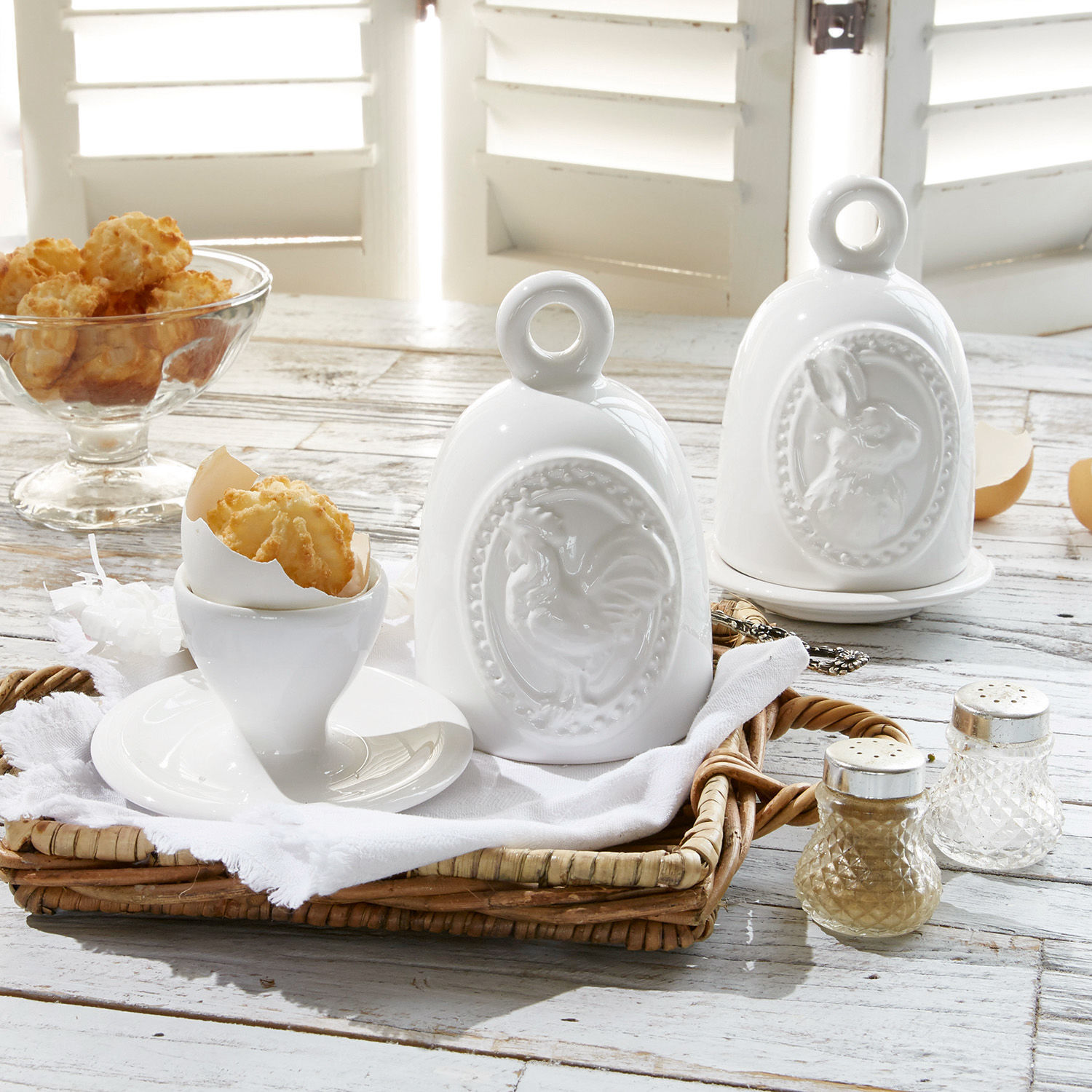 Lot de 2 coquetiers Celestyn Contenants en céramique blanche avec motifs coq et lapin sur table en bois rustique avec snacks