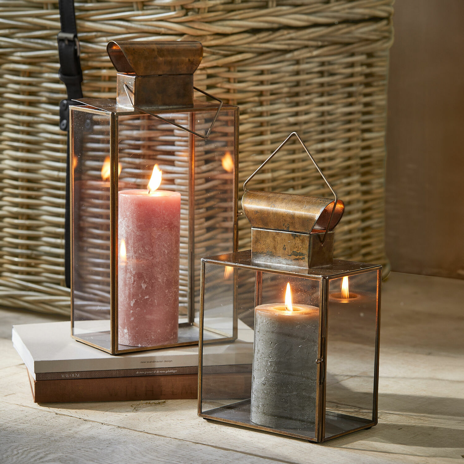 Lot de 2 lanternes Pluton Deux lanternes en métal avec finition cuivre et parois en verre contenant des bougies allumées