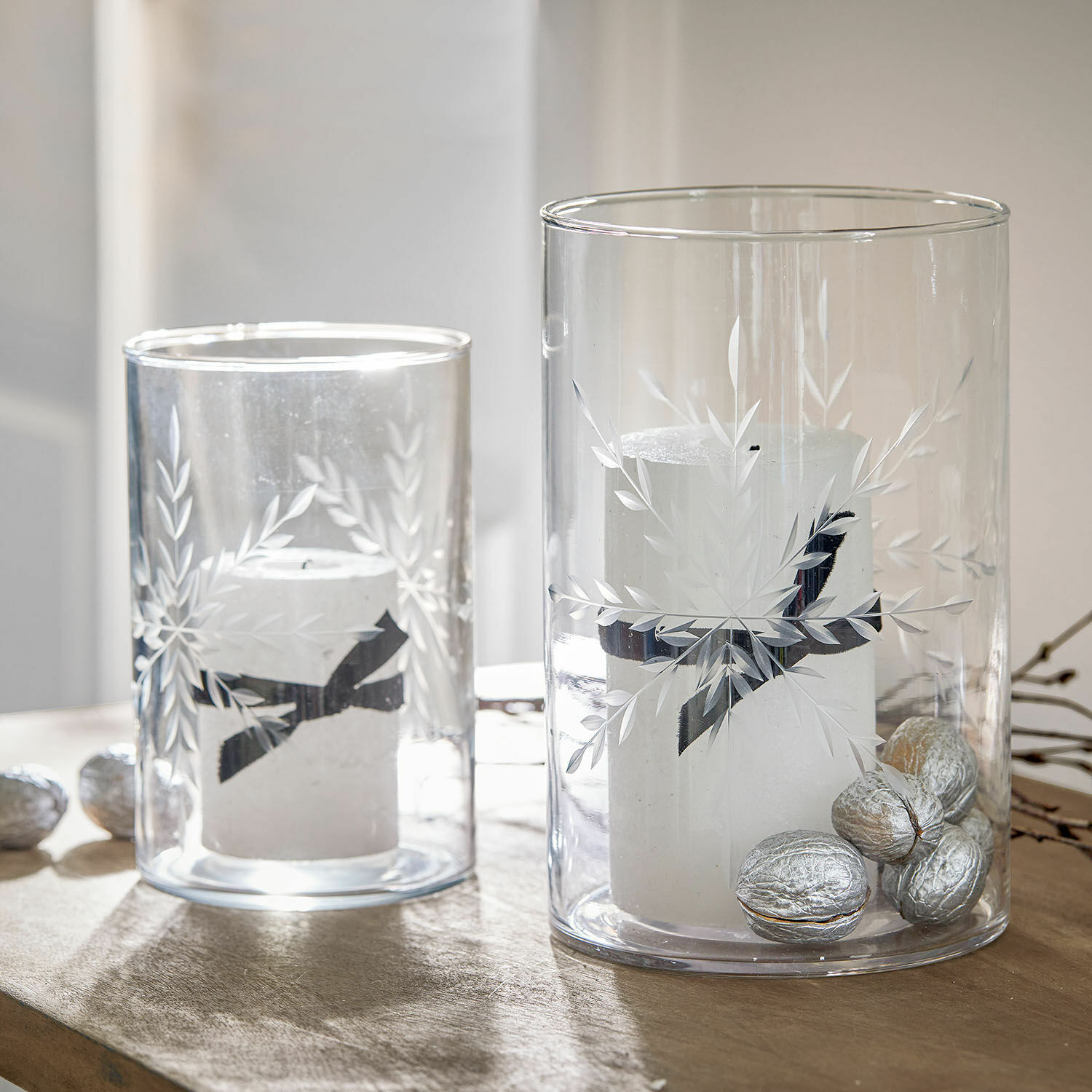 Lot de 2 photophores Snowflakes Photophores en verre avec bougies blanches et noix argentées sur table en bois, décoration festive