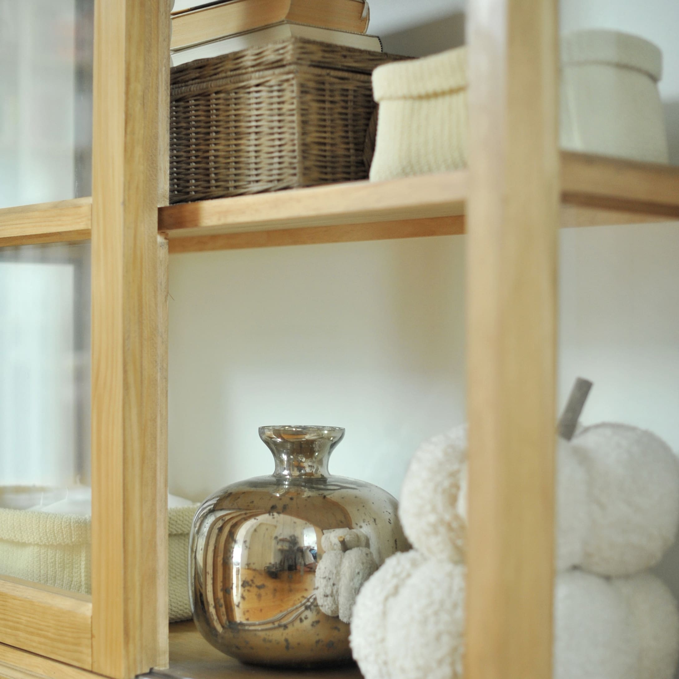 Vase décoratif argenté sur étagère en bois avec panier en osier et décoration blanche douce