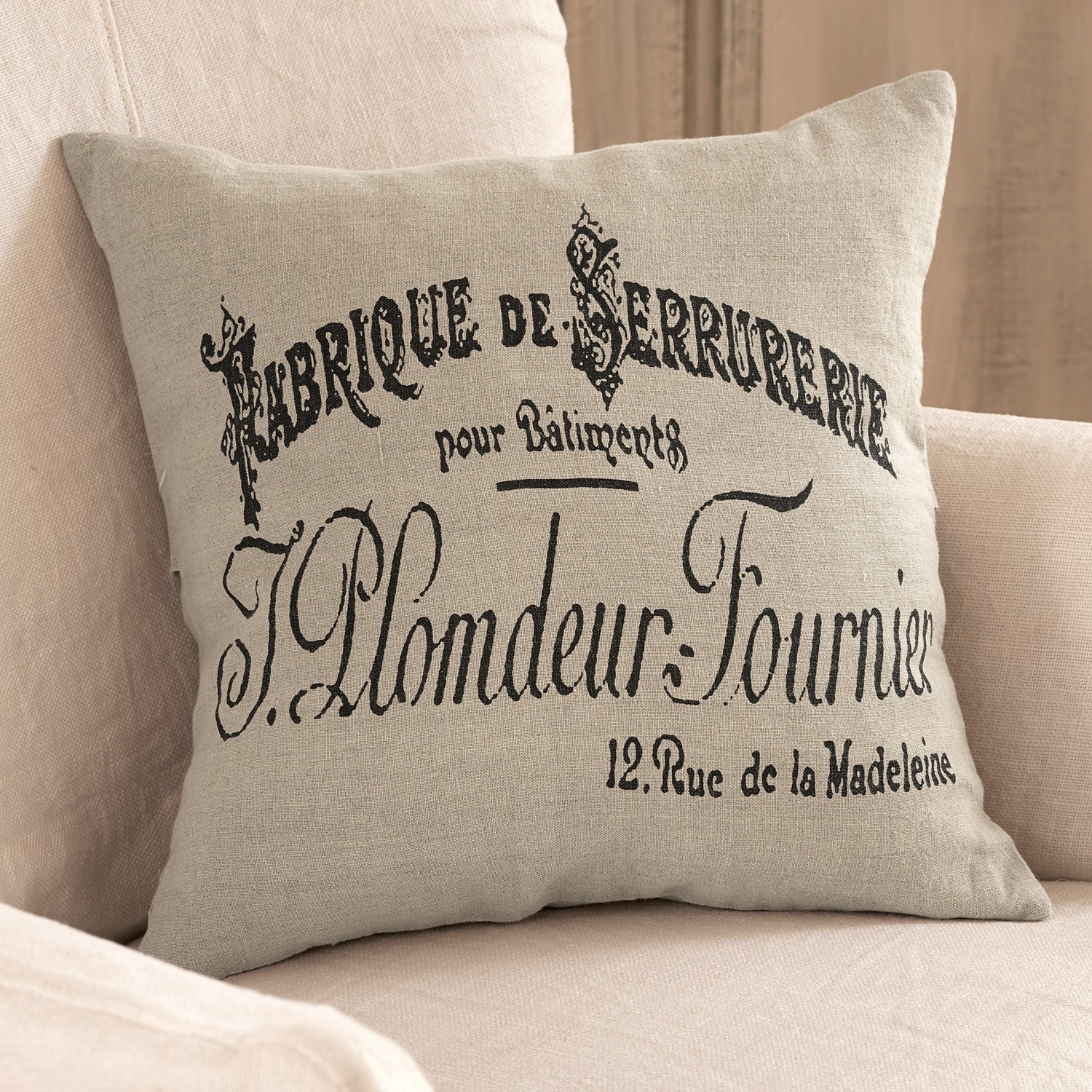 Housse de coussin Darby Coussin en lin beige avec impression française noire sur canapé clair, décoration intérieure