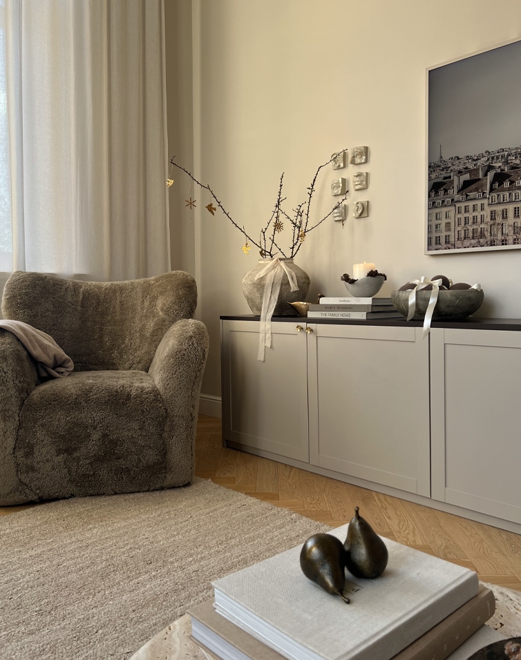 Coin d'hiver chaleureux avec fauteuil doux et buffet clair dans des tons naturels pour salon