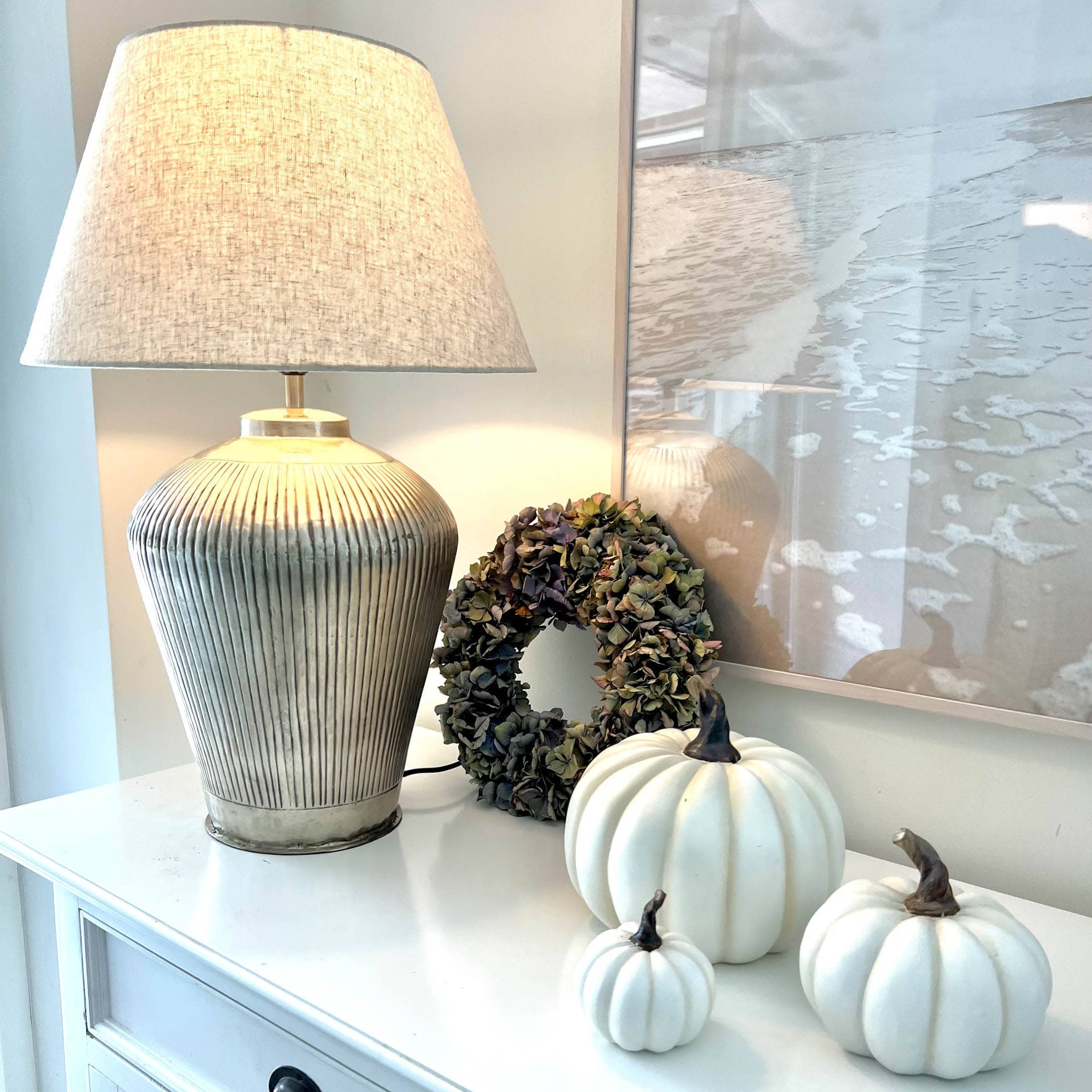 Lampe de table avec abat-jour beige et base en céramique, citrouilles blanches décoratives et couronne de fleurs séchées