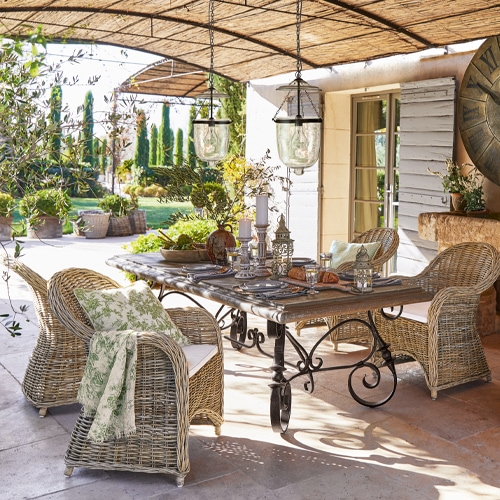 Ensemble de mobilier de jardin en osier et métal naturel sur terrasse avec décorations et luminaires