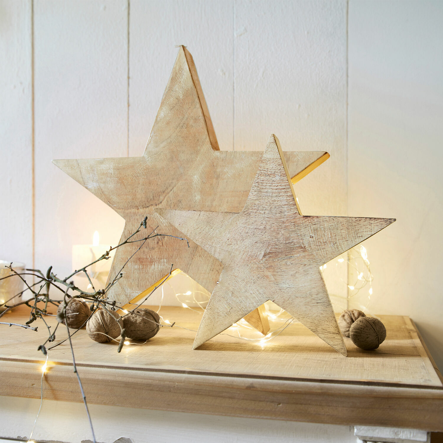 Lot de 2 étoiles Dunino Décorations en bois en forme d'étoile couleur naturelle sur table festive avec noix et guirlandes lumineuses LED