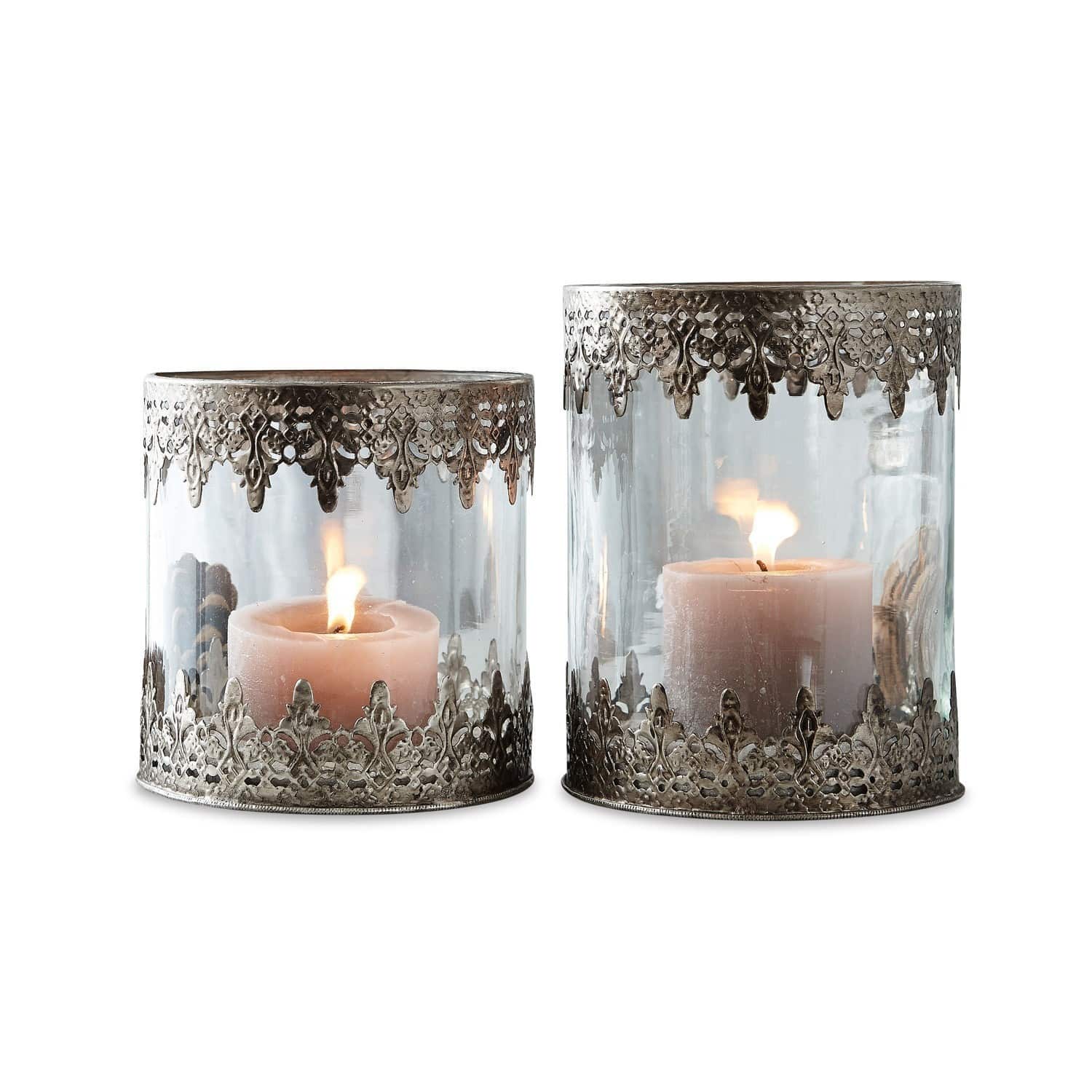 Lot de 2 photophores Lauriane Ensemble de deux photophores en verre avec décor en métal argenté ajouré et bougies allumées à l'intérieur