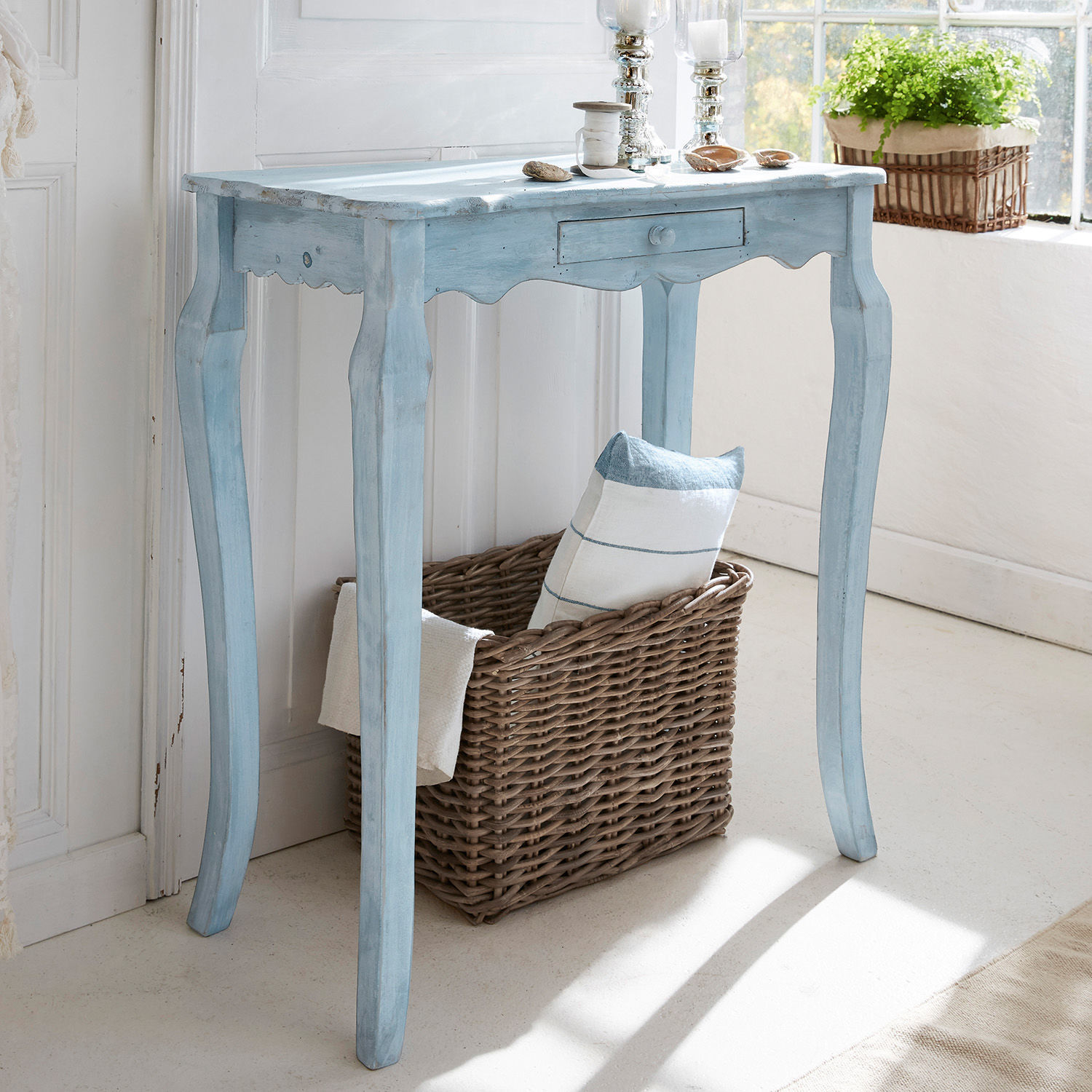 Console Barbey Table en bois bleue vintage avec tiroir et panier en osier, décorée près d'une fenêtre lumineuse