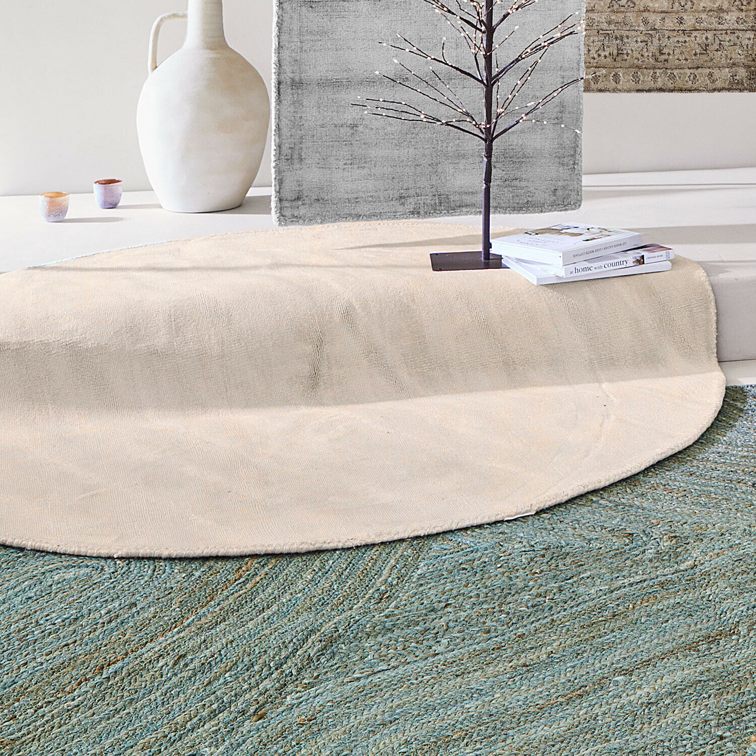Tapis Mariselle Tapis rond beige en matériau naturel posé sur un tapis vert dans un intérieur moderne