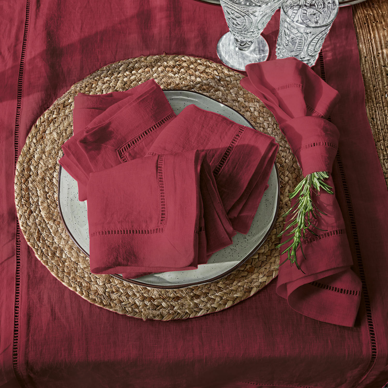 Lot de 4 serviettes Covent Garden Nappe et serviettes en lin bordeaux sur un dessous de table tressé avec romarin décoratif