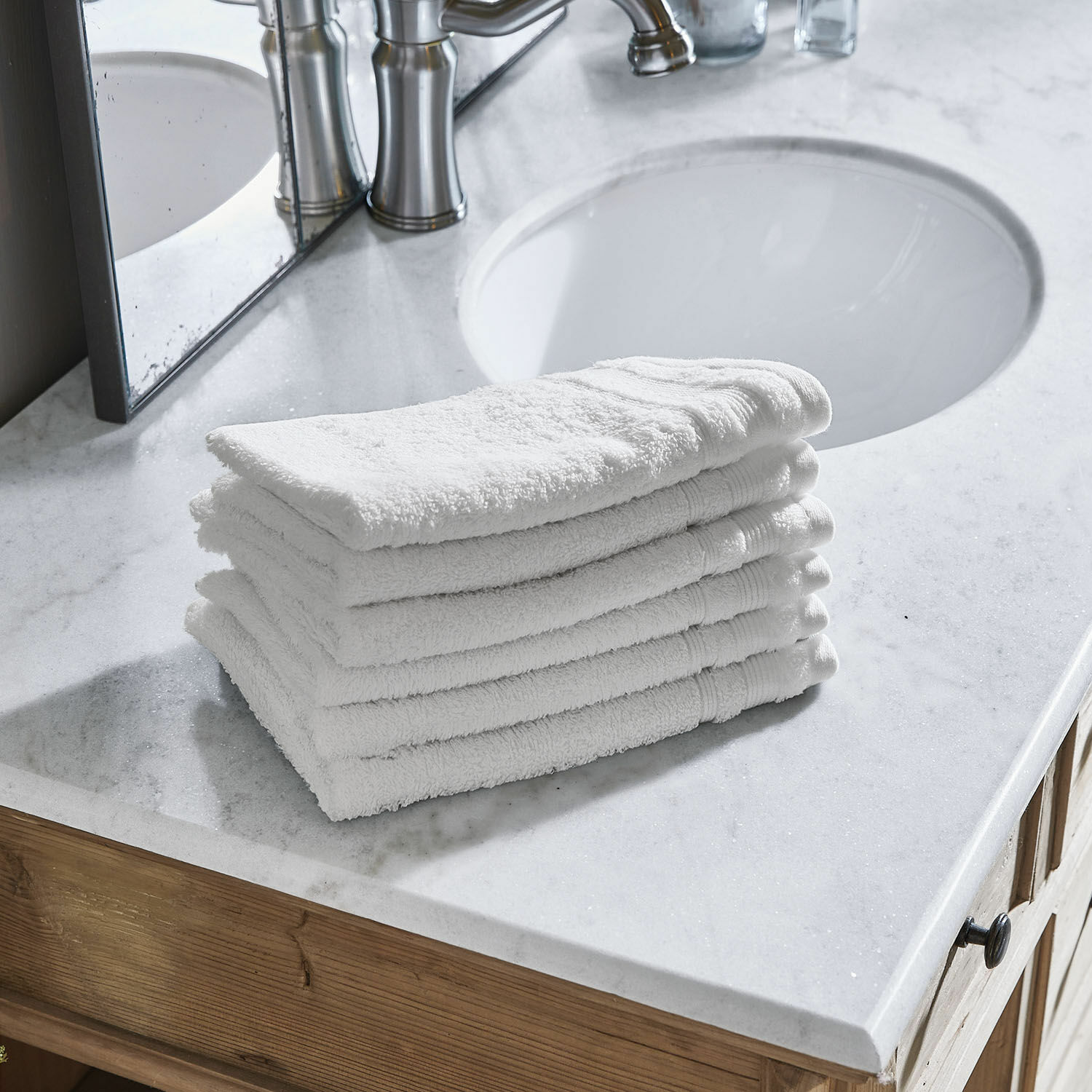 Lot de 6 serviettes d’invités Bourogne Pile de serviettes blanches en coton sur un lavabo en marbre avec meuble en bois dans la salle de bain