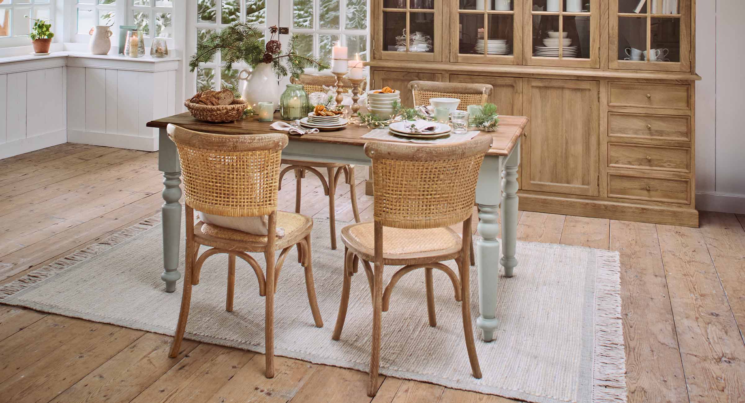 Petit déjeuner d'Avent chaleureux sur table en bois avec chaises en osier et décorations festives