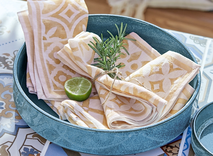 Bol en céramique bleue avec serviettes en lin beige et blanc, tranche de citron vert, style méditerranéen