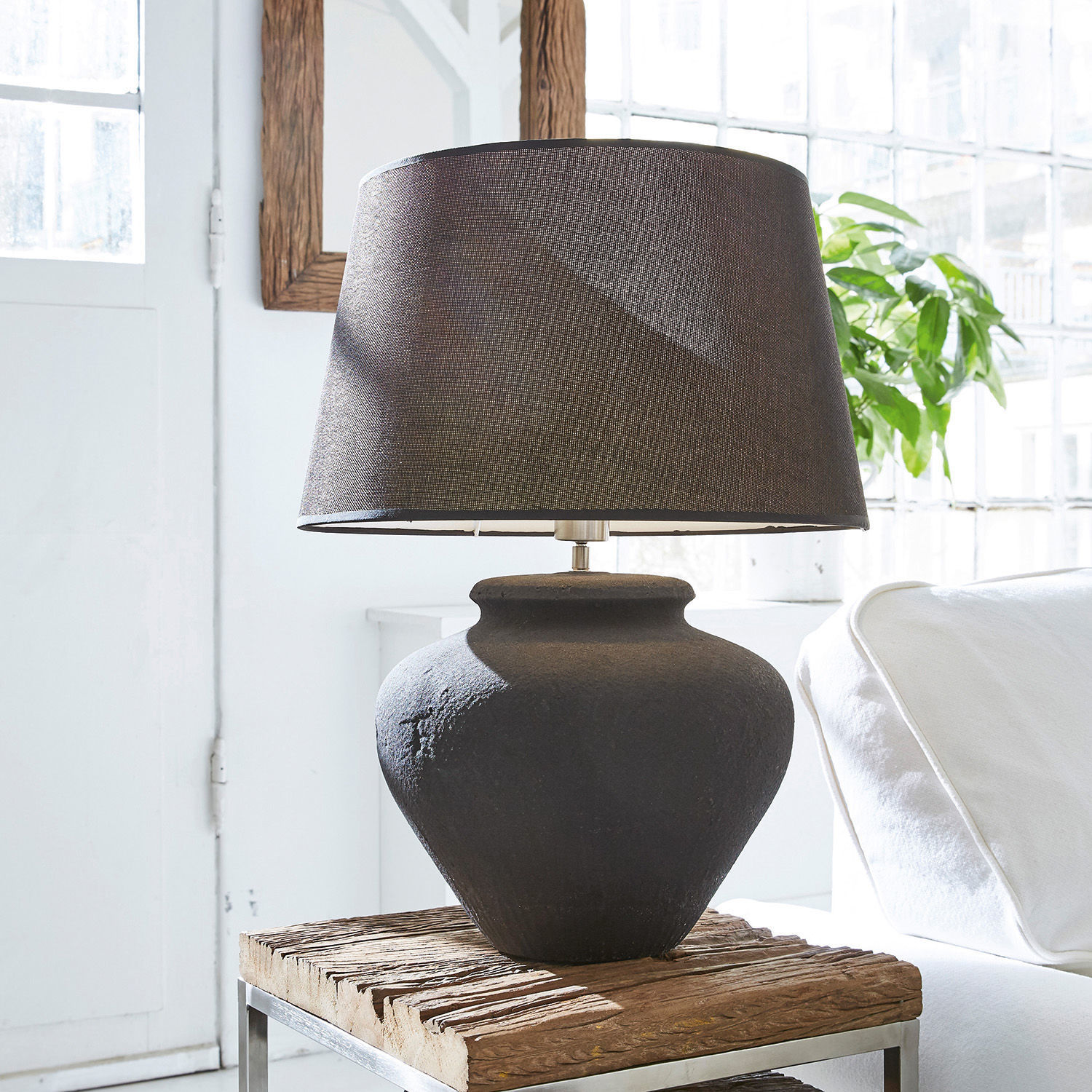 Lampe à poser Bandol Lampe de table noire en céramique avec abat-jour en tissu sur une table en bois dans un intérieur lumineux