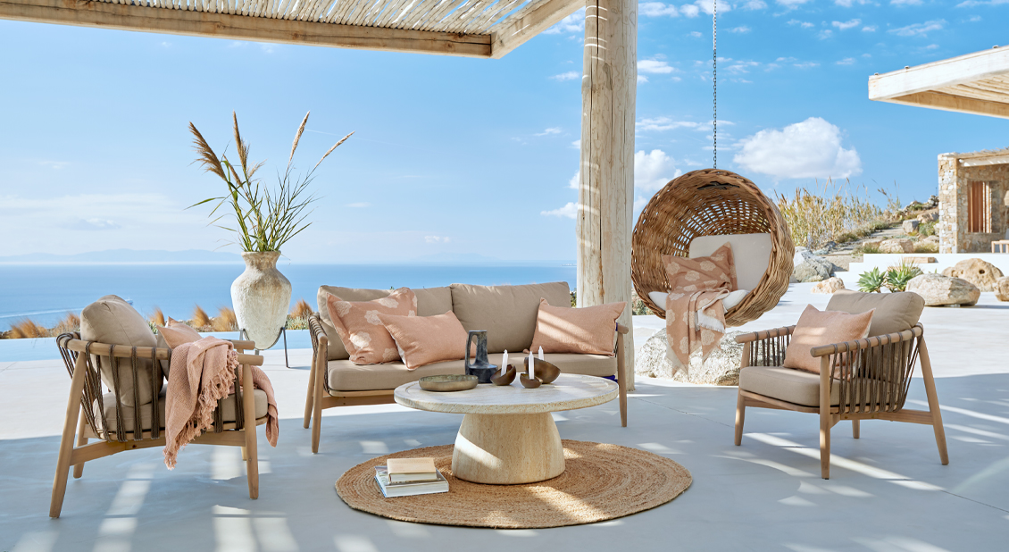 Ensemble de mobilier d'extérieur beige avec fauteuil suspendu en osier et vue sur la mer