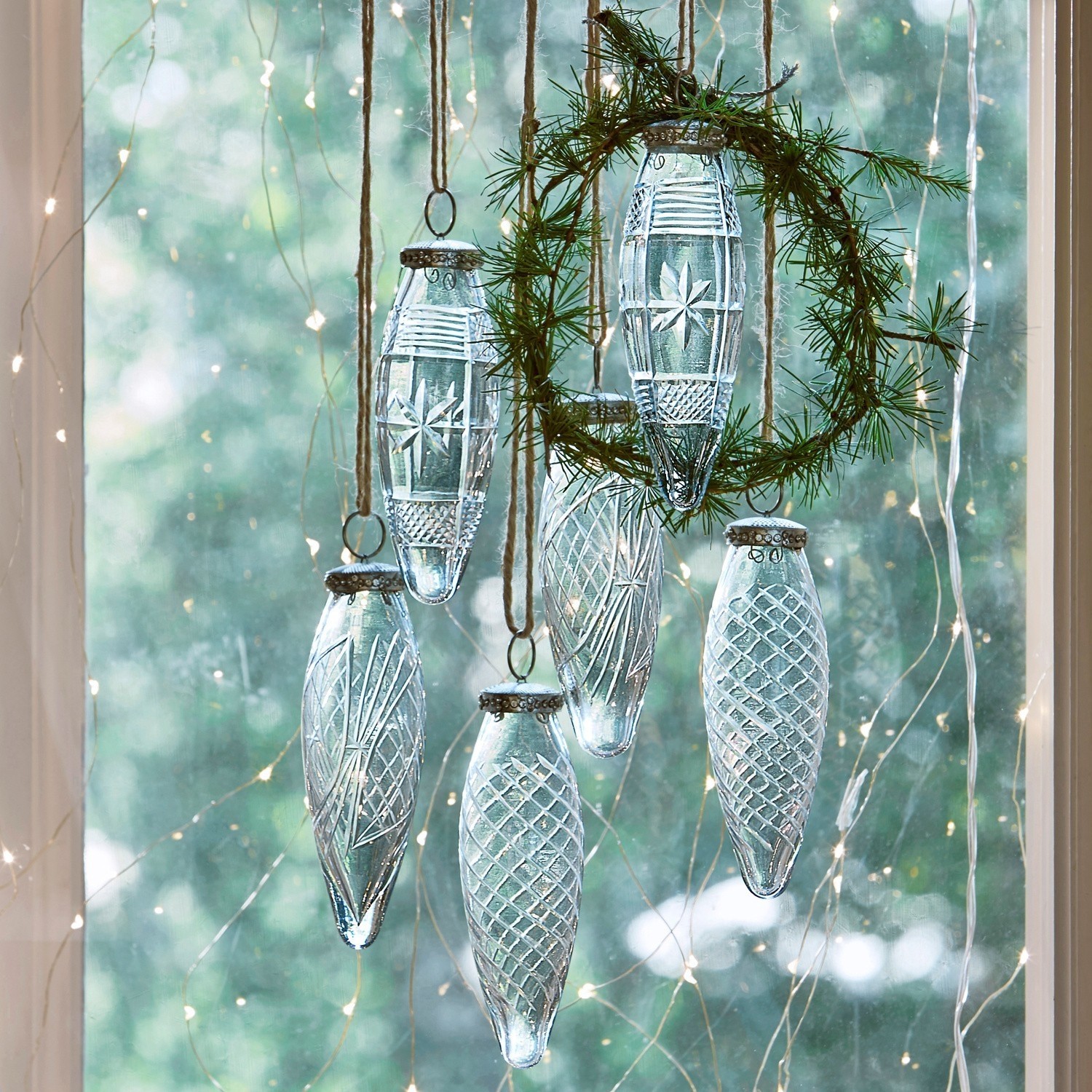 Lot de 6 décorations de Noël Loulay Décorations de Noël en verre transparent avec motifs suspendues à des cordes devant une fenêtre éclairée par des guirlandes LED