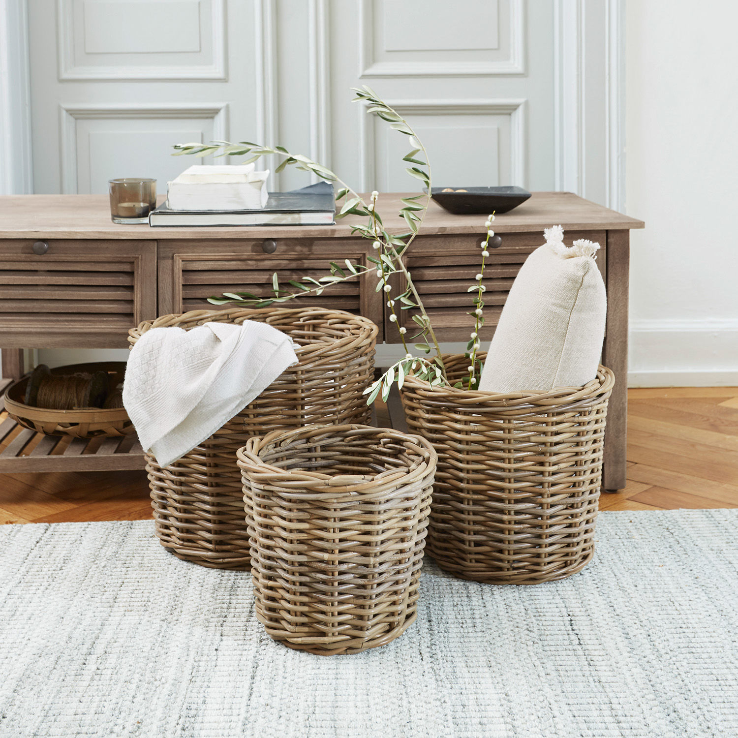 Lot de 3 paniers Avar Ensemble de trois paniers en osier couleur naturelle pour rangement intérieur sur tapis clair.