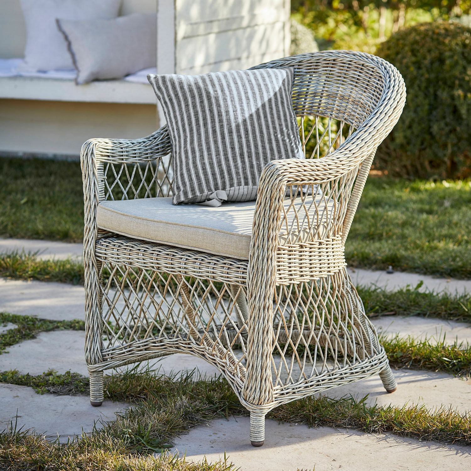 Fauteuil Lézardrieux Fauteuil d'extérieur en rotin clair avec coussin rayé, parfait pour un coin détente dans le jardin