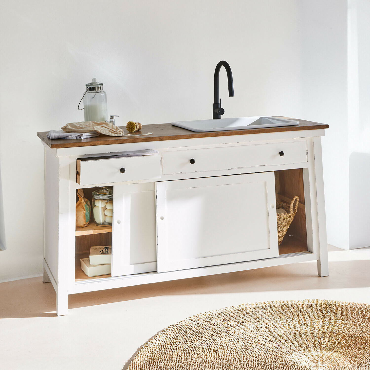 Meuble en bois blanc avec plan de travail en bois foncé, évier blanc et robinet noir, tiroirs ouverts