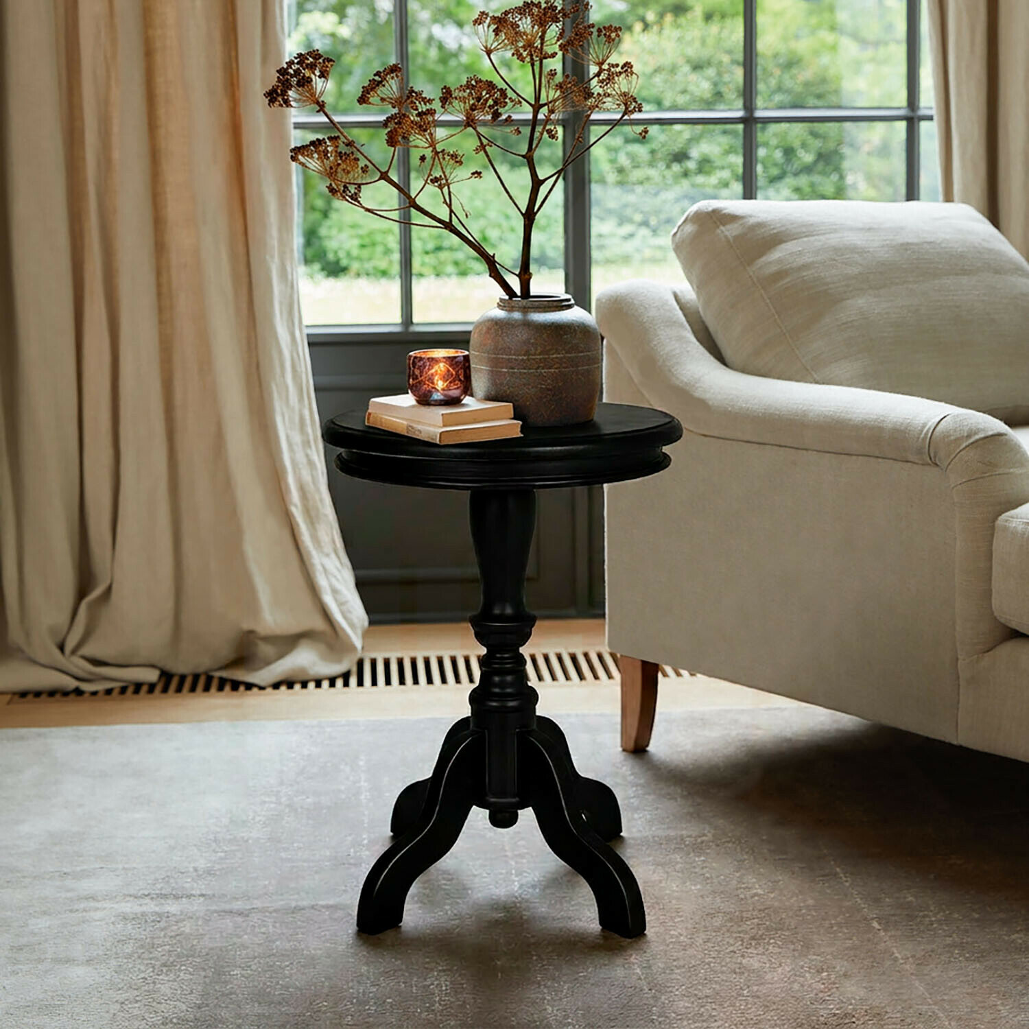 Table d’appoint Mengomeyen Table d'appoint noire en bois avec vase et bougie à côté d'un canapé beige dans un salon lumineux