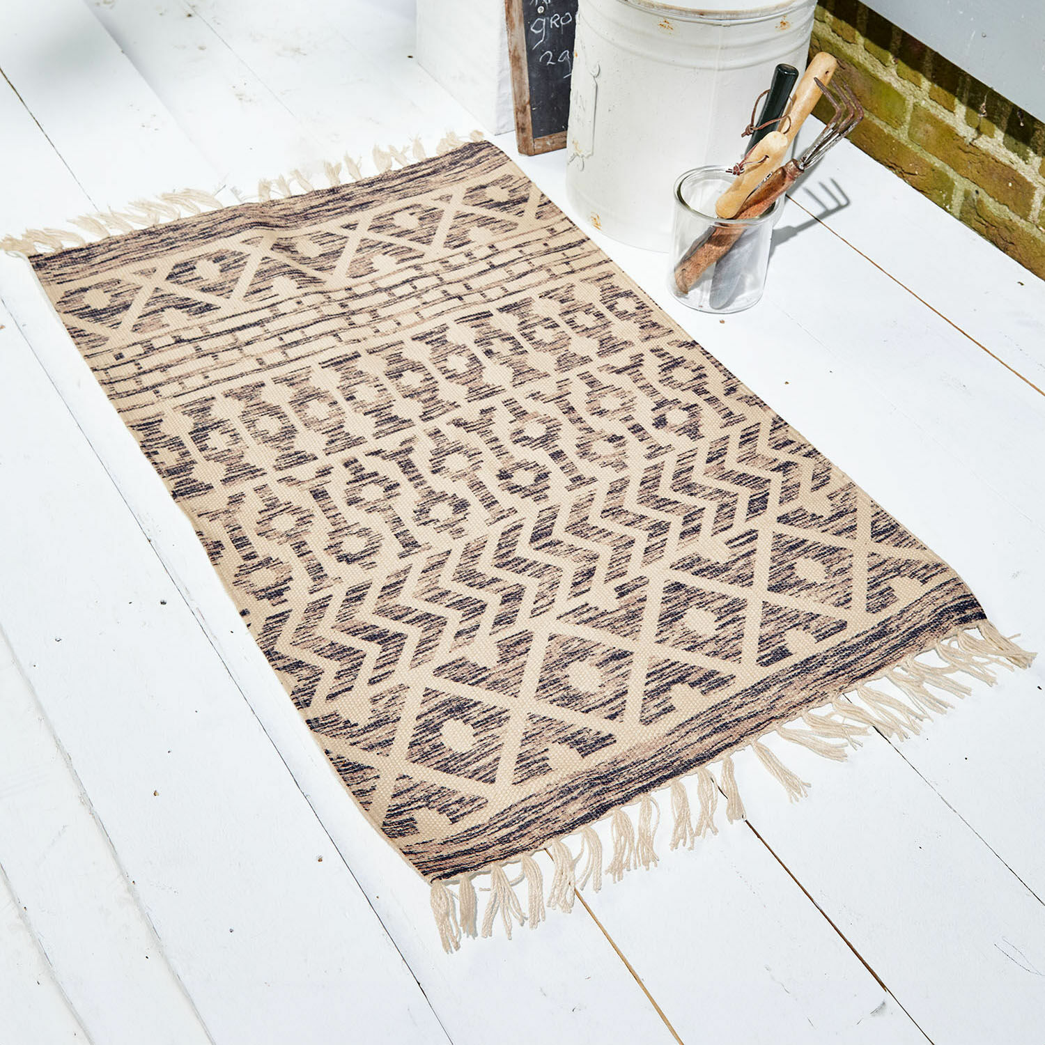 Tapis intérieur et extérieur Champigny Tapis beige à motifs géométriques avec franges sur un sol blanc, décoration intérieure tendance
