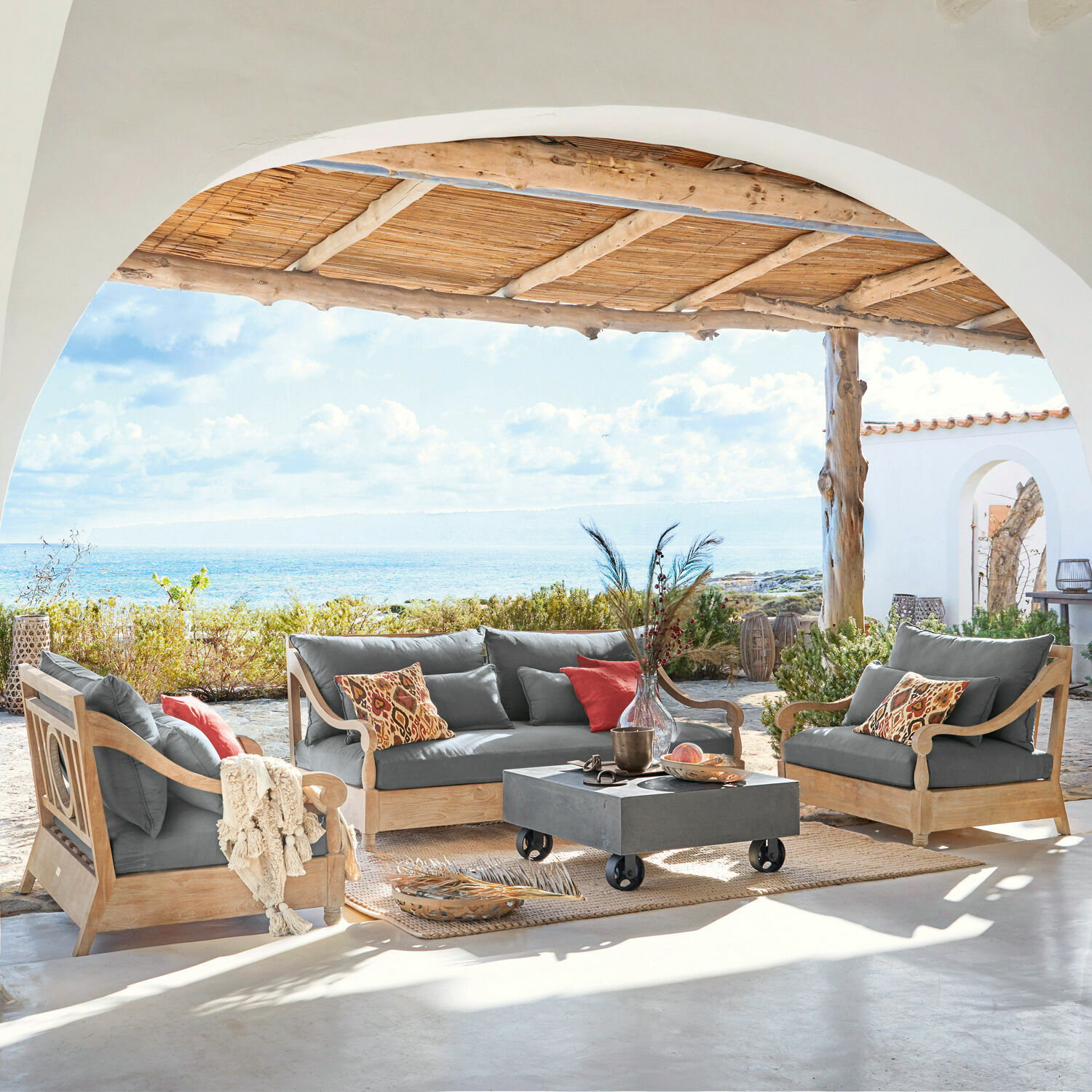 Salon de jardin Montcassin Ensemble de mobilier de jardin en bois avec coussins gris sur terrasse face à la mer
